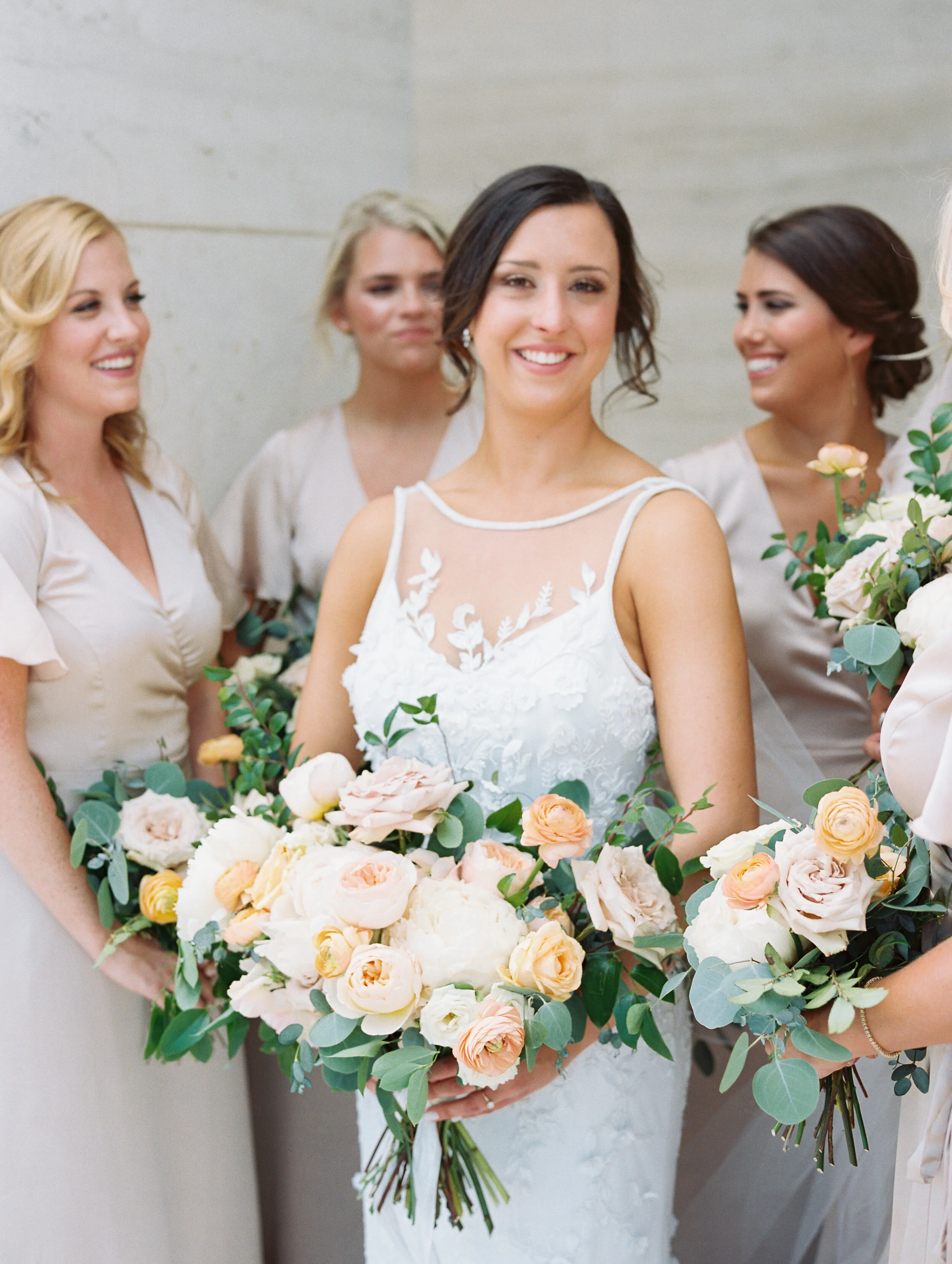 Bridal bouquet with peach ranunculus, cream peonies, blush and golden yellow garden roses, and natural, untamed greenery. June wedding at the Cordelle. Nashville Wedding Florist.