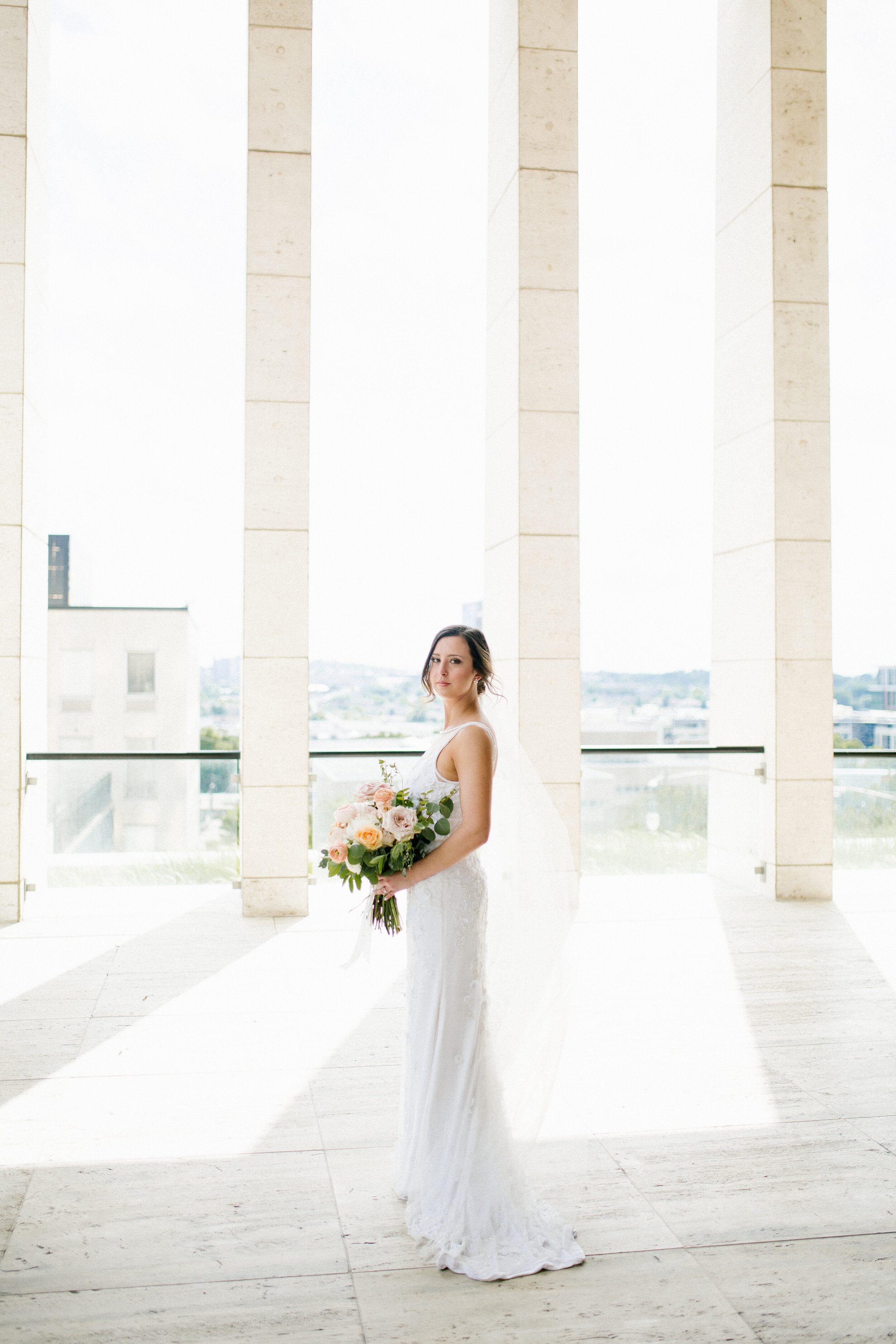 Bridal bouquet with peach ranunculus, cream peonies, blush and golden yellow garden roses, and natural, untamed greenery. June wedding at the Cordelle. Nashville Wedding Florist.
