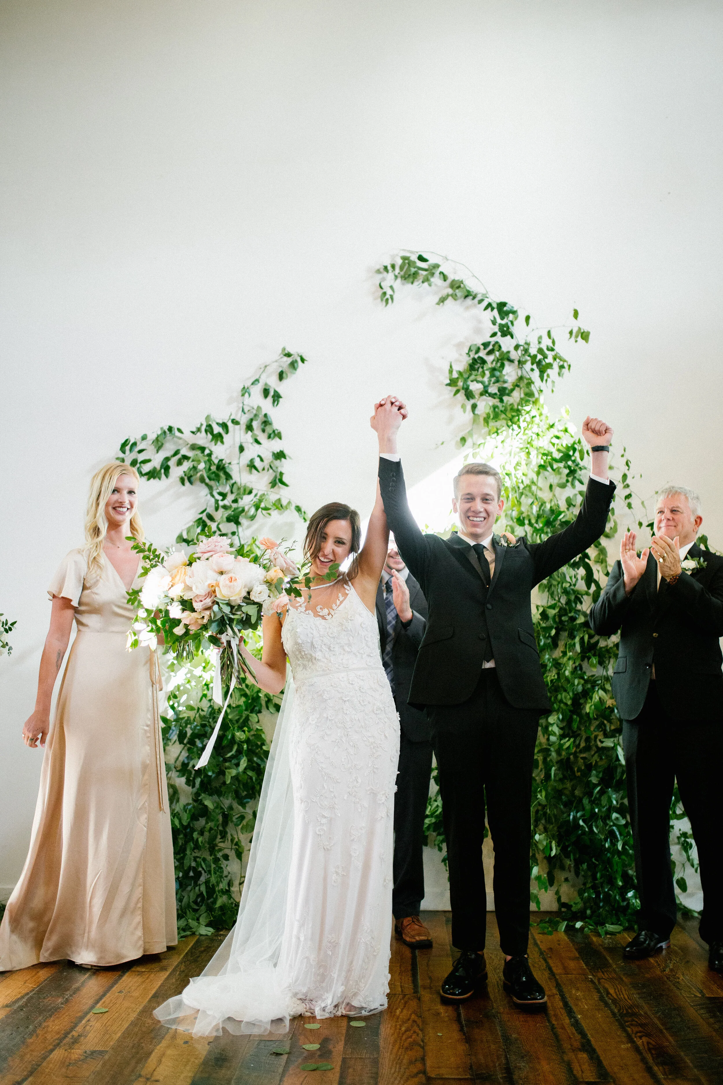 Lush, garden-inspired bouquets with peach, white, and dusty rose flowers and natural greenery. Champagne silk bridesmaid dresses. Nashville wedding florist.
