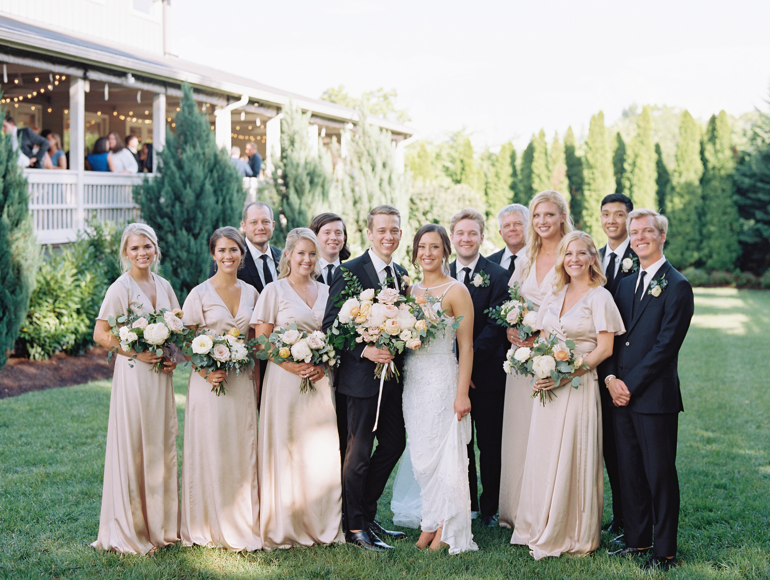 Lush, garden-inspired bouquets with peach, white, and dusty rose flowers and natural greenery. Champagne silk bridesmaid dresses. Nashville wedding florist.