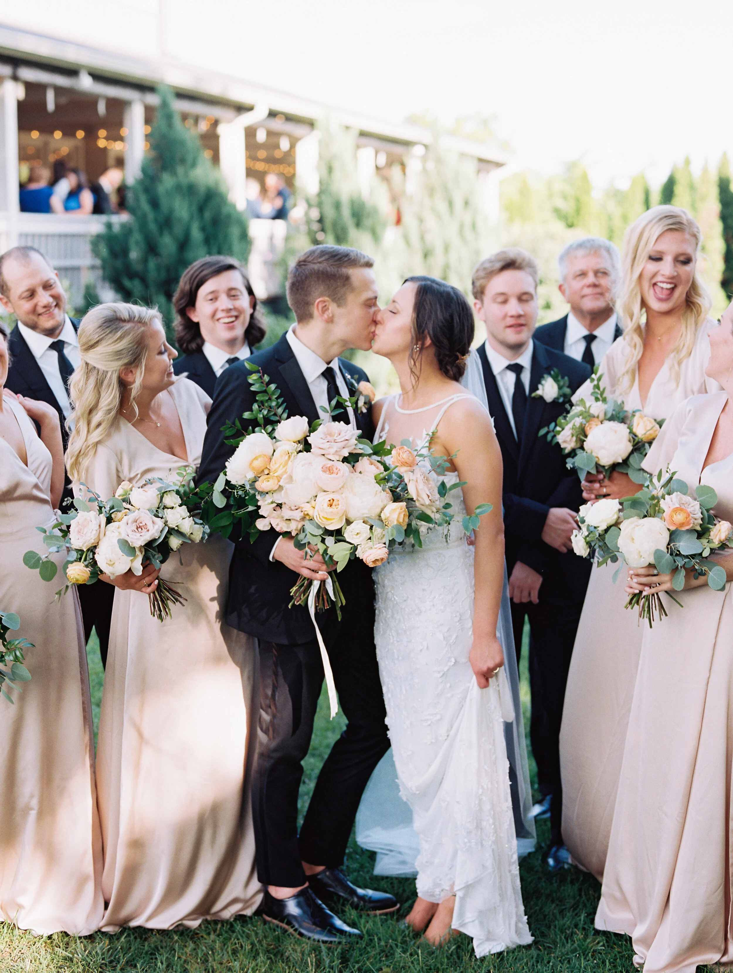 Lush, garden-inspired bouquets with peach, white, and dusty rose flowers and natural greenery. Champagne silk bridesmaid dresses. Nashville wedding florist.