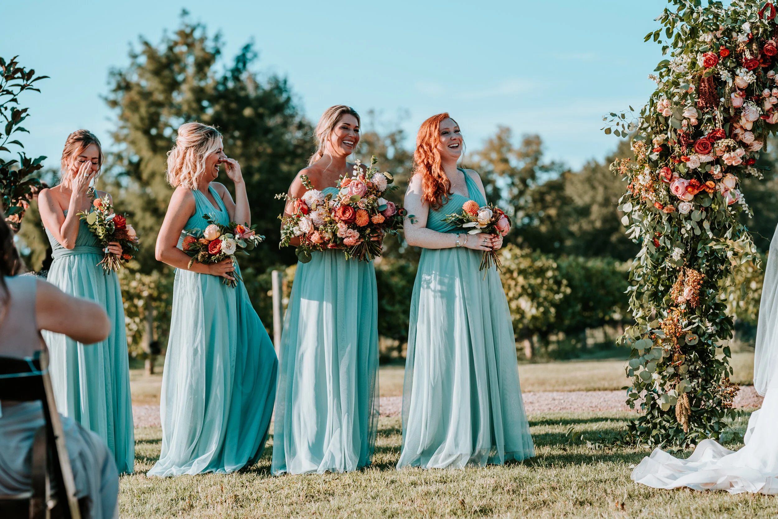 Lush floral arch for a fall wedding at Long Hollow Gardens with untamed greenery, berries, and rust orange garden roses.