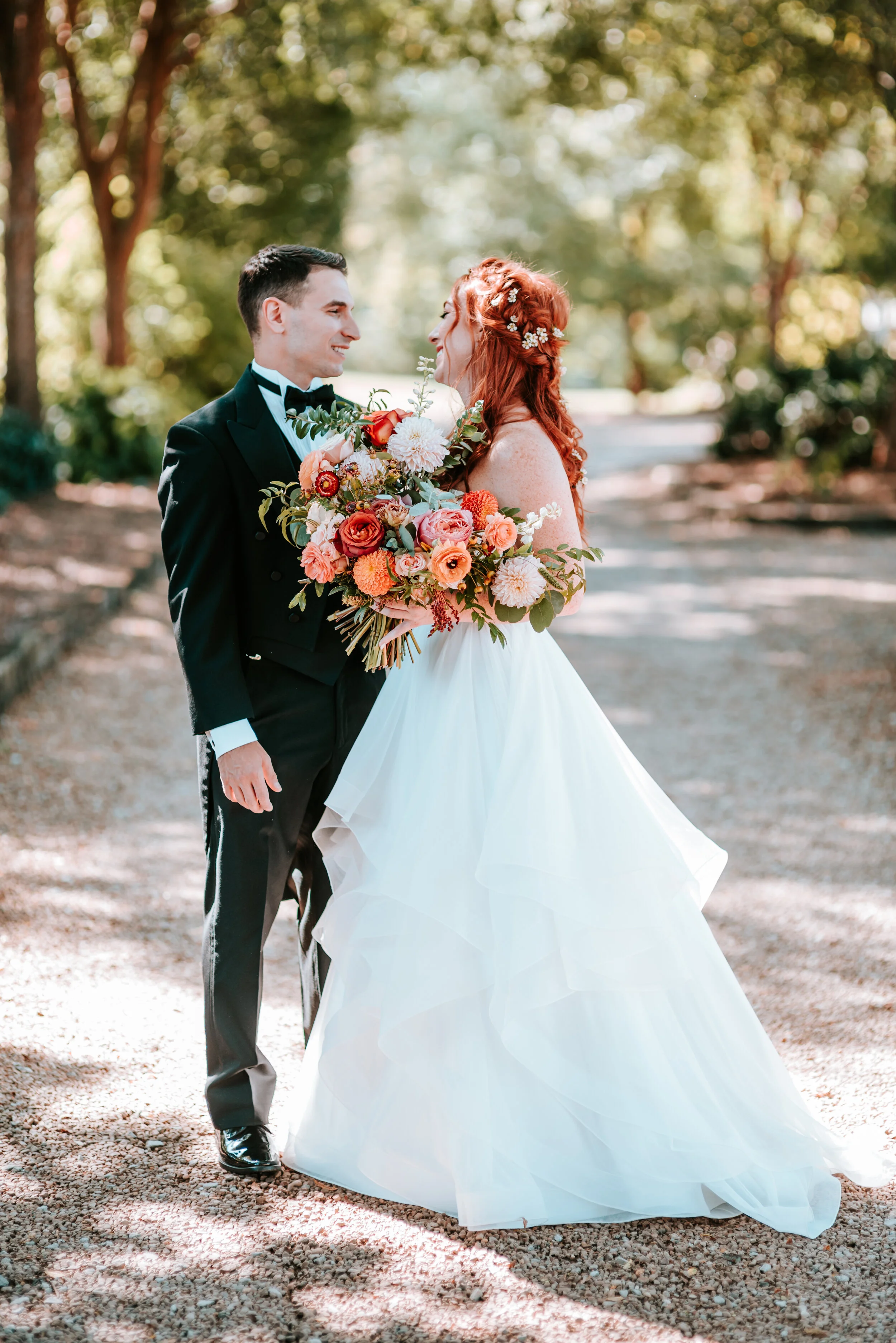 Fall bridal bouquet with garden roses, dahlias, and ranunculus in shades of burnt orange and peach, autumnal berries, and lush greenery. Nashville Wedding Floral Design.