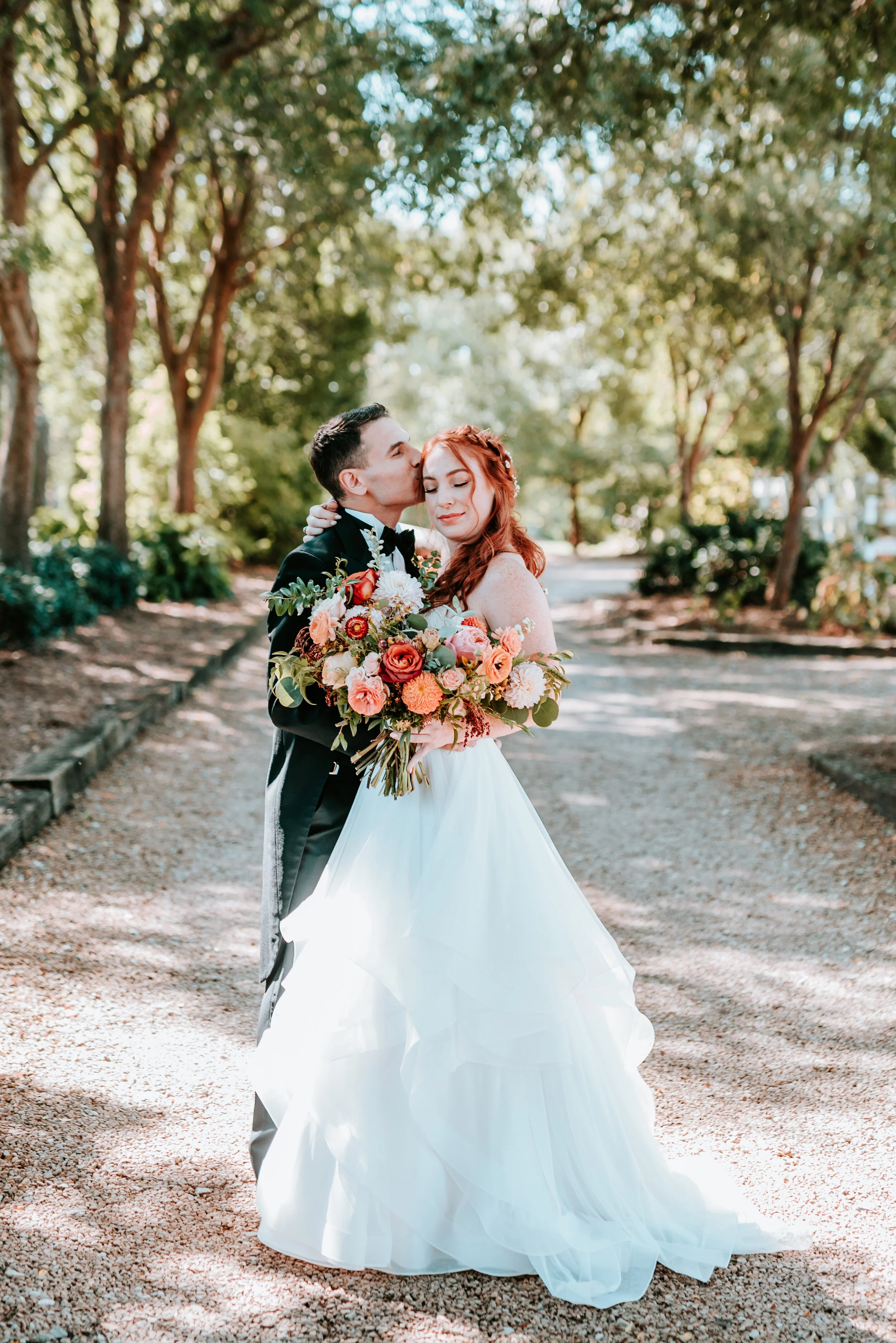 Fall bridal bouquet with garden roses, dahlias, and ranunculus in shades of burnt orange and peach, autumnal berries, and lush greenery. Nashville Wedding Floral Design.