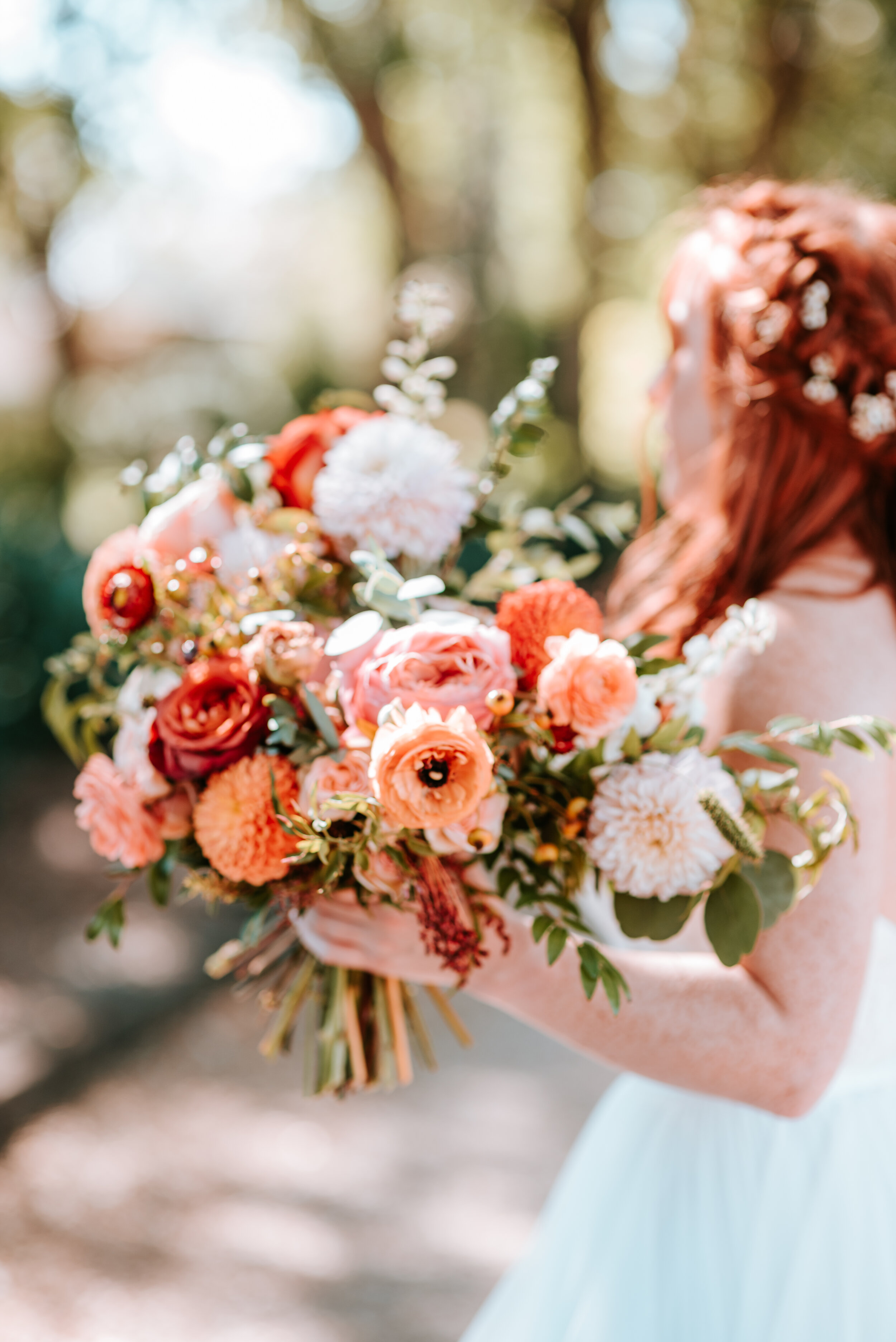 Fall bridal bouquet with garden roses, dahlias, and ranunculus in shades of burnt orange and peach, autumnal berries, and lush greenery. Nashville Wedding Floral Design.