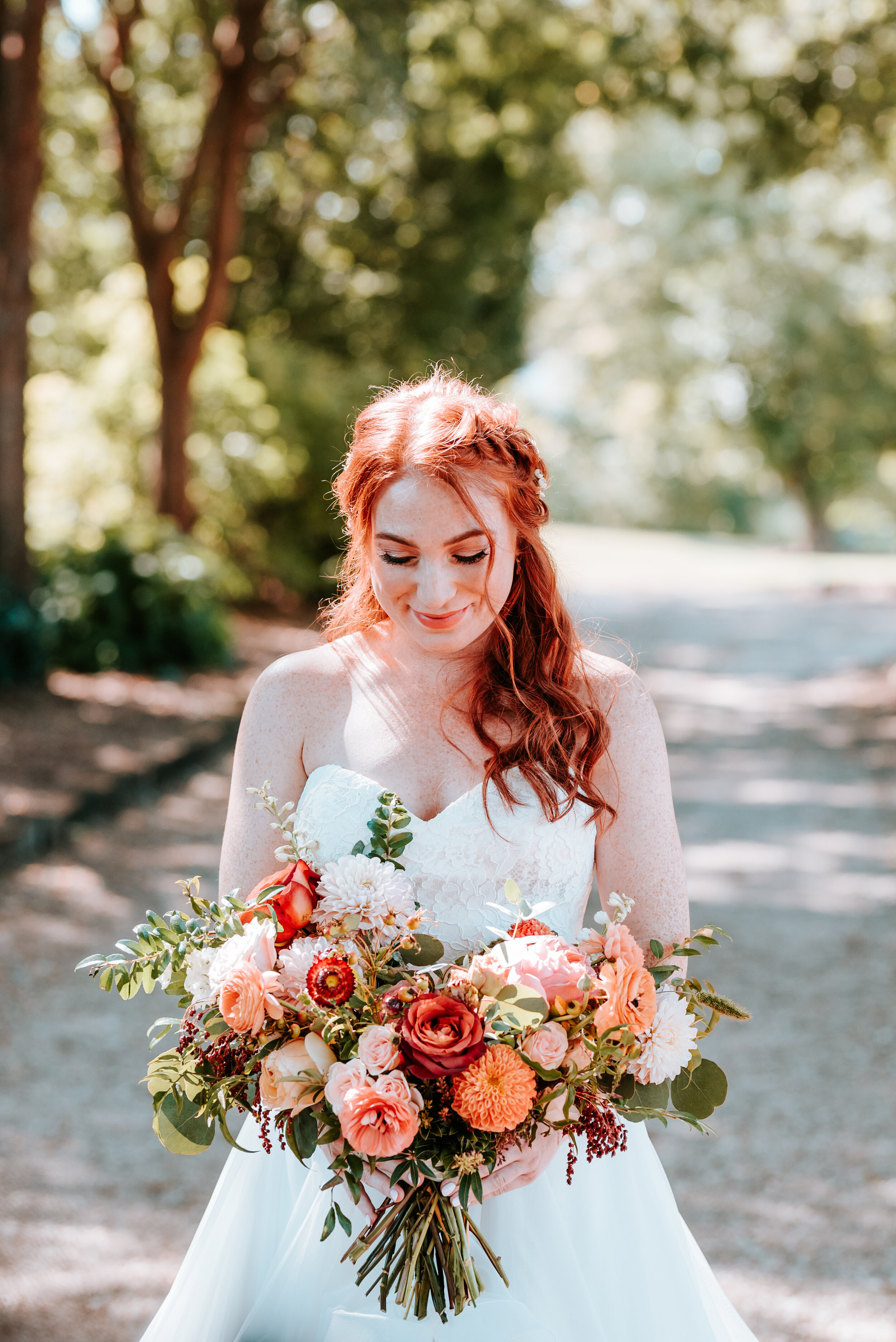 Fall bridal bouquet with garden roses, dahlias, and ranunculus in shades of burnt orange and peach, autumnal berries, and lush greenery. Nashville Wedding Floral Design.