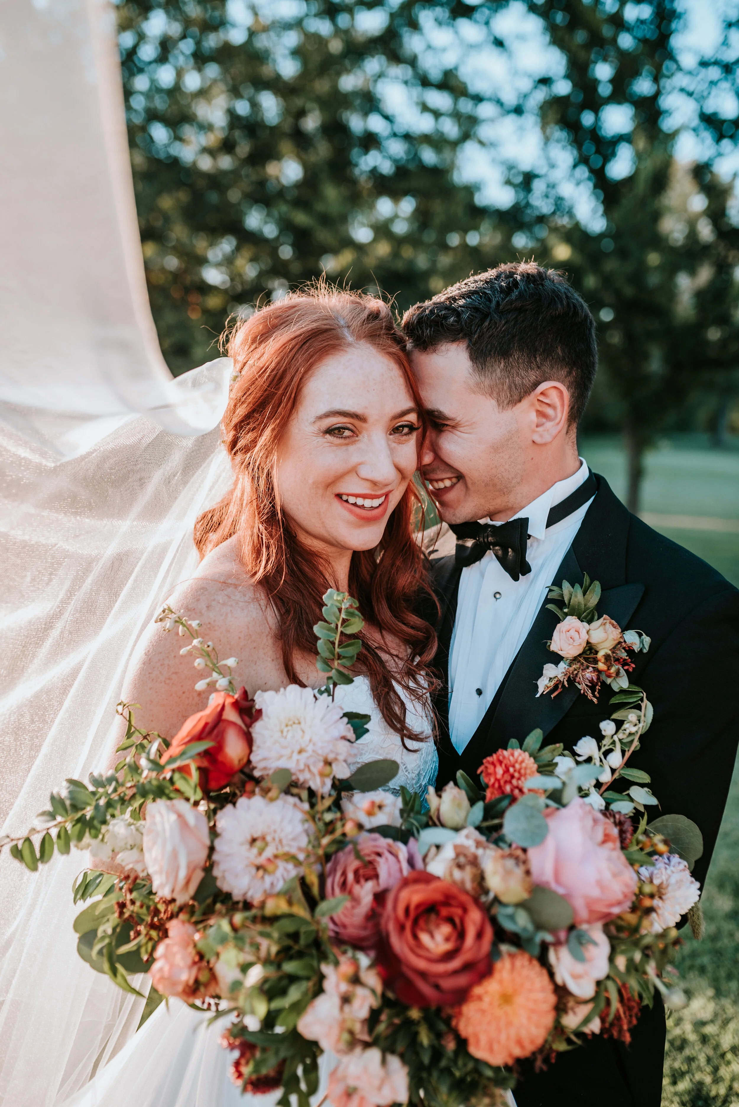 Fall bridal bouquet with garden roses, dahlias, and ranunculus in shades of burnt orange and peach, autumnal berries, and lush greenery. Nashville Wedding Floral Design.