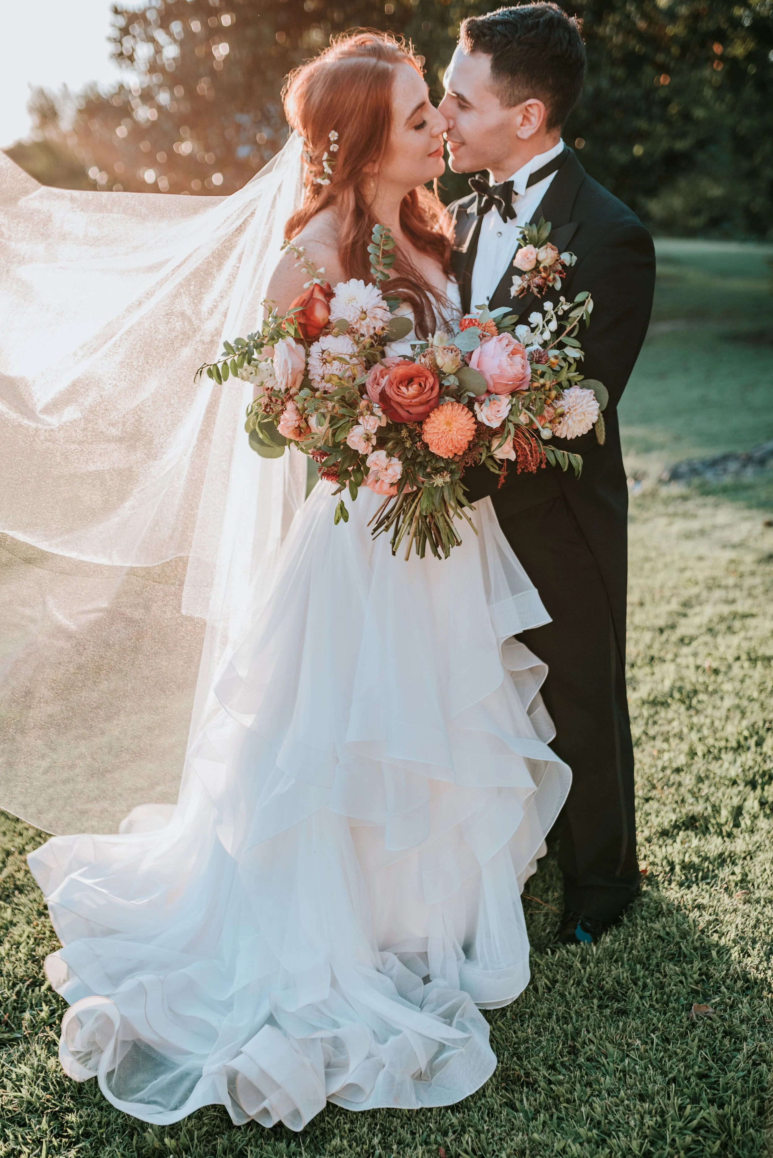 Fall bridal bouquet with garden roses, dahlias, and ranunculus in shades of burnt orange and peach, autumnal berries, and lush greenery. Nashville Wedding Floral Design.