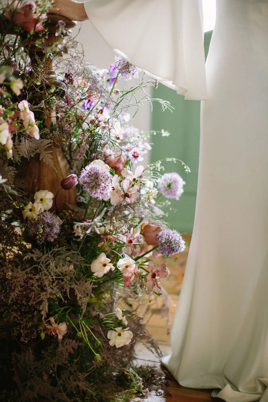 Spiral staircase with a lush, airy floral installation in a lavender and lilac color palette with spirea, painted plumosa ferns, heather, allium, ranunculus, and garden roses. Nashville Wedding Floral Design.