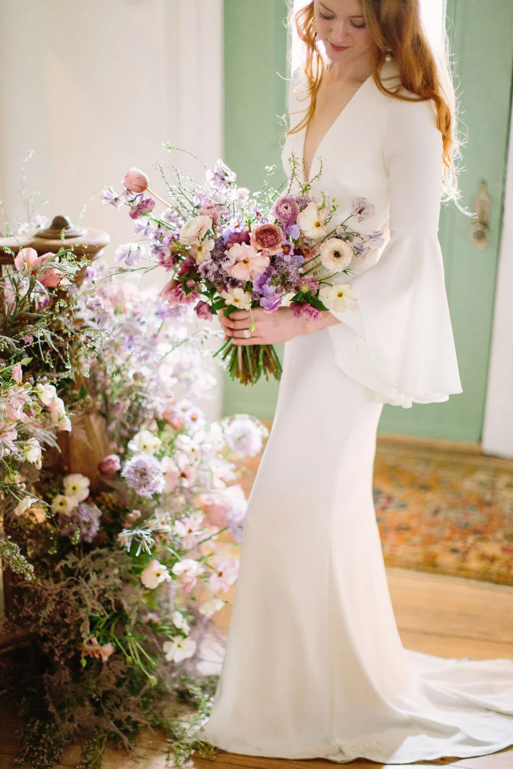 Spiral staircase with a lush, airy floral installation in a lavender and lilac color palette with spirea, painted plumosa ferns, heather, allium, ranunculus, and garden roses. Nashville Wedding Floral Design.