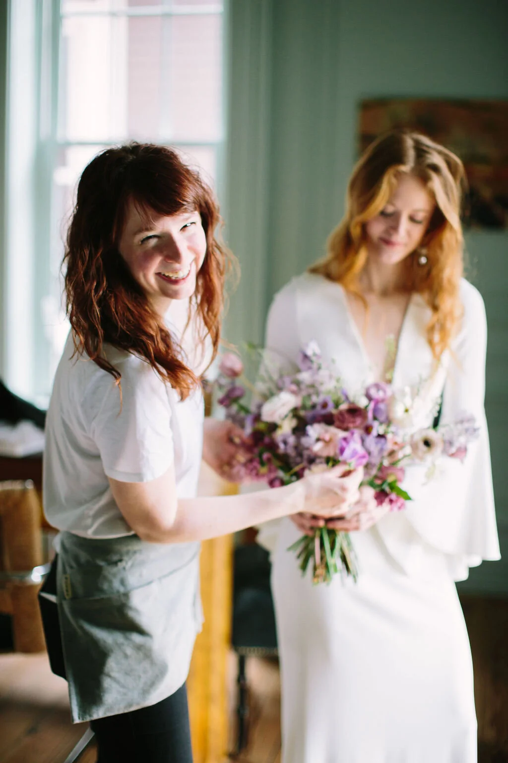 Whimsical and organic purple bridal bouquet with delicate spring flowers like spirea, ranunculus, sweet peas, and tulips. Nashville wedding florist.