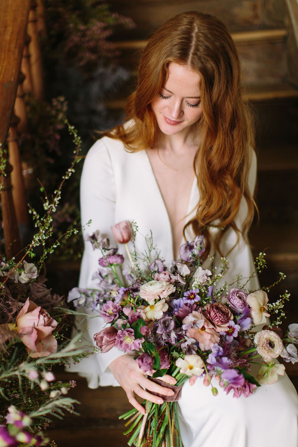 Whimsical and organic purple bridal bouquet with delicate spring flowers like spirea, ranunculus, sweet peas, and tulips. Nashville wedding florist.