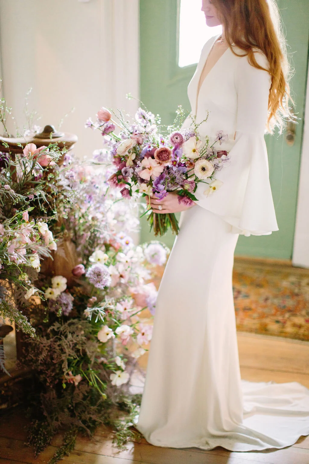 Whimsical and organic purple bridal bouquet with delicate spring flowers like spirea, ranunculus, sweet peas, and tulips. Nashville wedding florist.