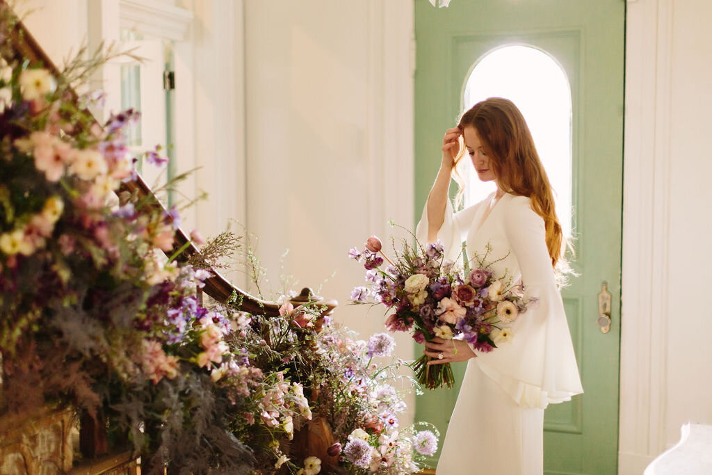 Whimsical and organic purple bridal bouquet with delicate spring flowers like spirea, ranunculus, sweet peas, and tulips. Nashville wedding florist.