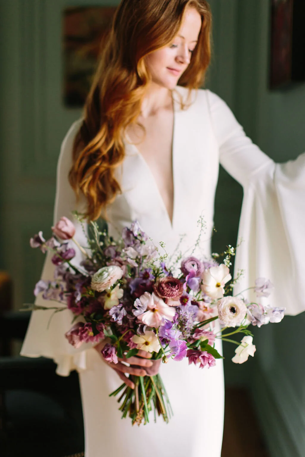 Whimsical and organic purple bridal bouquet with delicate spring flowers like spirea, ranunculus, sweet peas, and tulips. Nashville wedding florist.