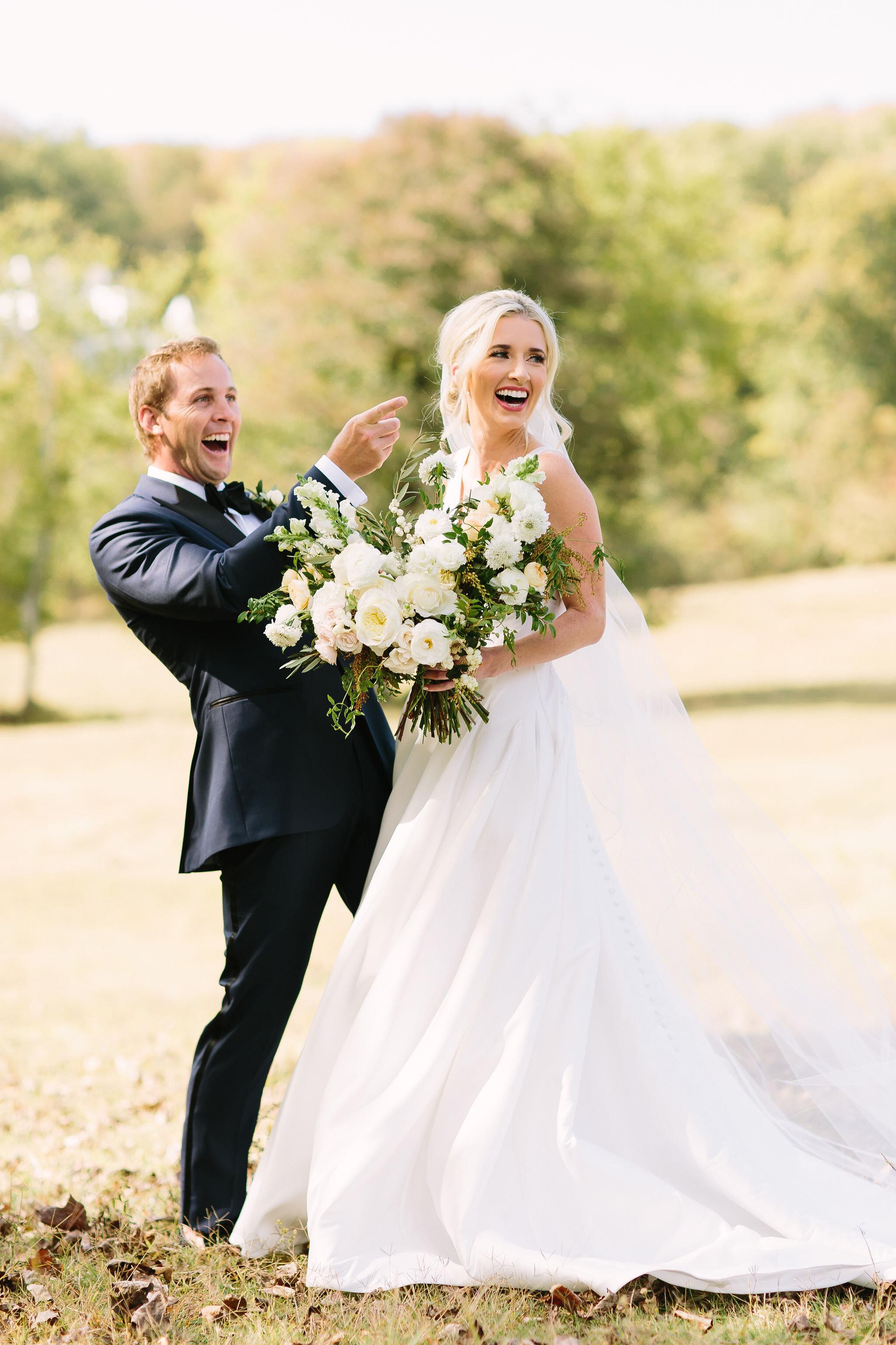 All white bridal bouquet with garden roses, ranunculus, snapdragons, scabiosa, and trailing greenery. Organic wedding floral design in Nashville, TN.