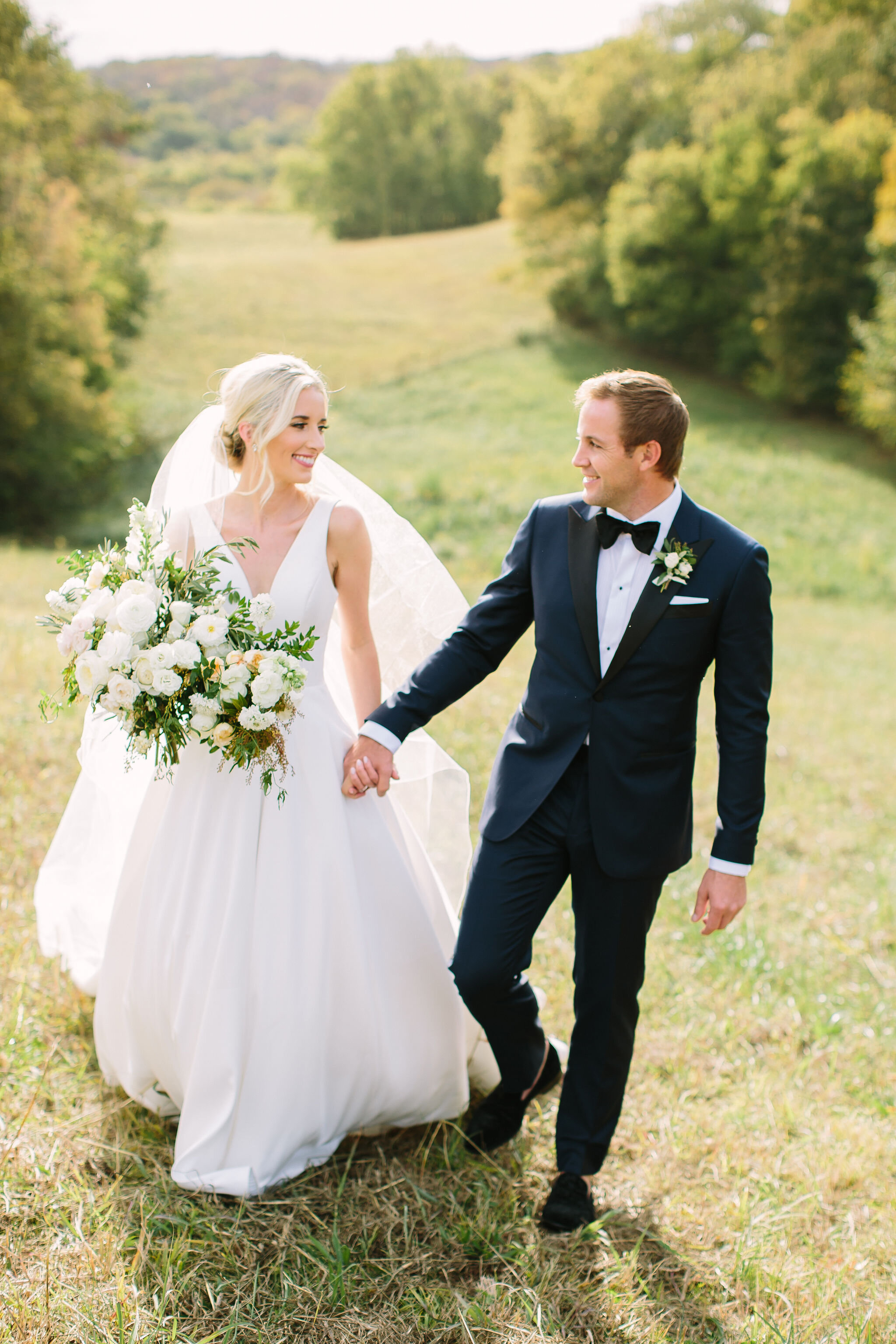 All white bridal bouquet with garden roses, ranunculus, snapdragons, scabiosa, and trailing greenery. Organic wedding floral design in Nashville, TN.