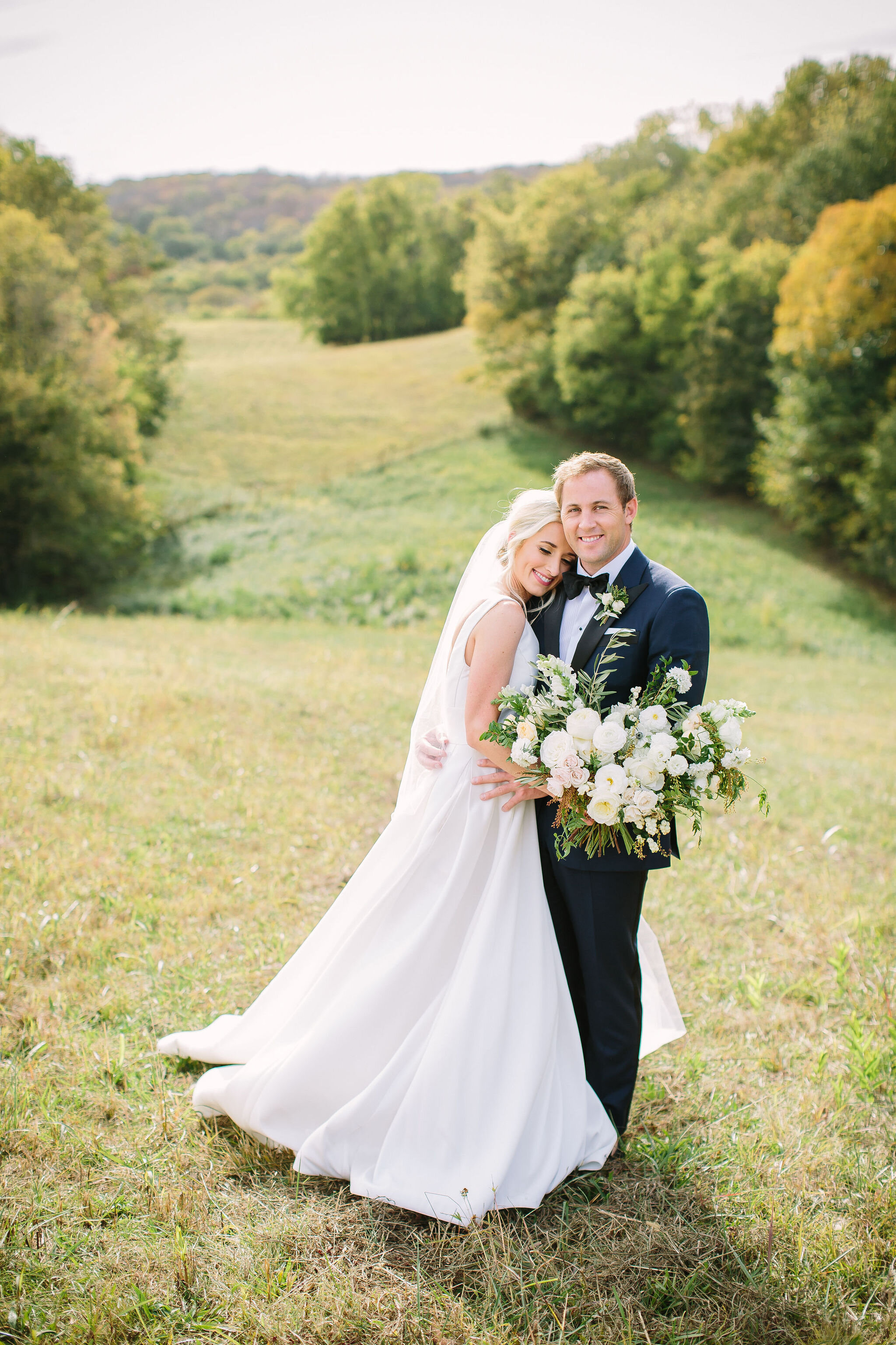 All white bridal bouquet with garden roses, ranunculus, snapdragons, scabiosa, and trailing greenery. Organic wedding floral design in Nashville, TN.