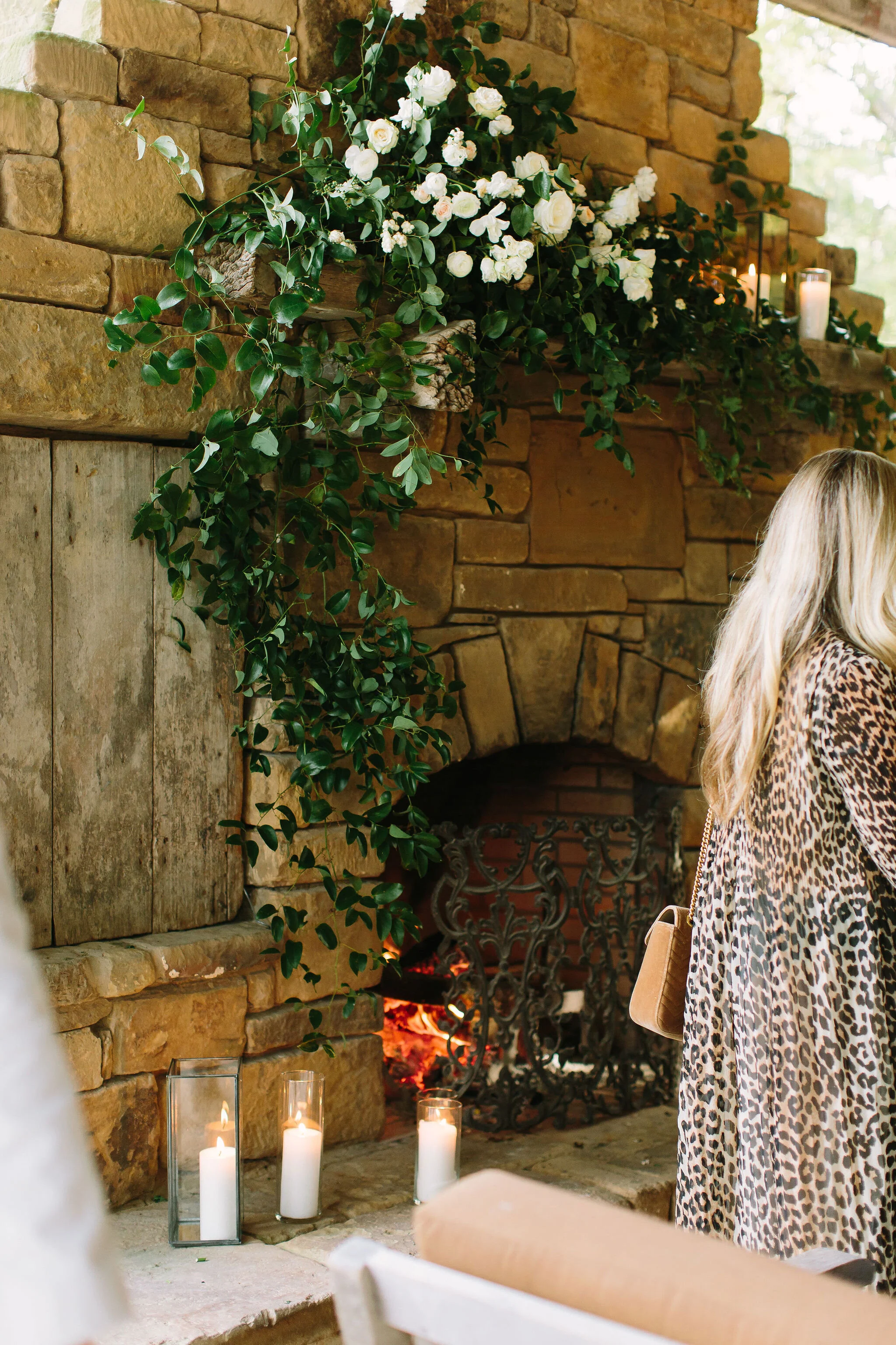 Asymmetrical floral installation for the mantle with trailing vines and white flowers. Wedding floral design at Bloomsbury Farms.