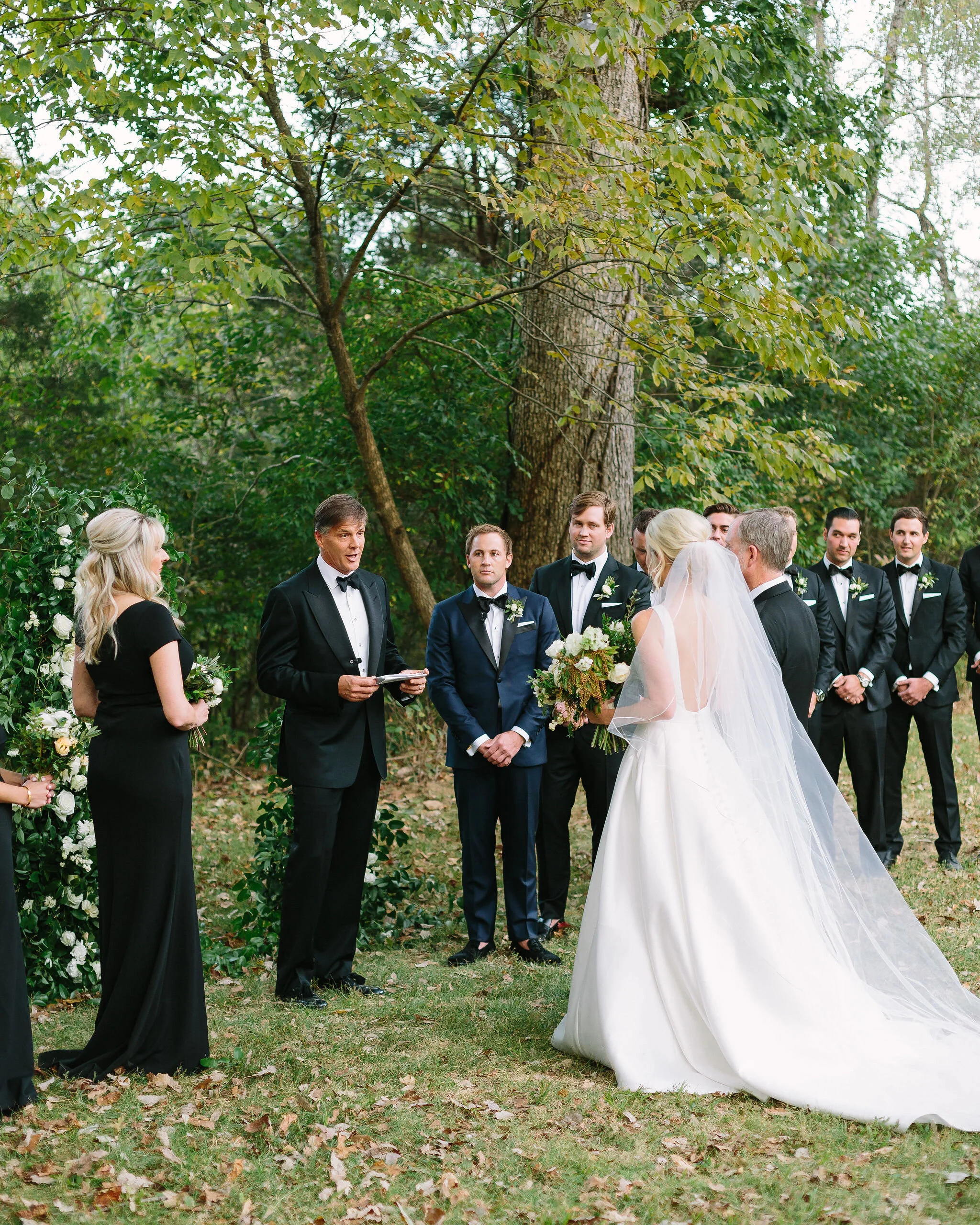 Growing, asymmetrical floral installation for the wedding ceremony backdrop. All white flowers and natural greenery. Nashville wedding florist.