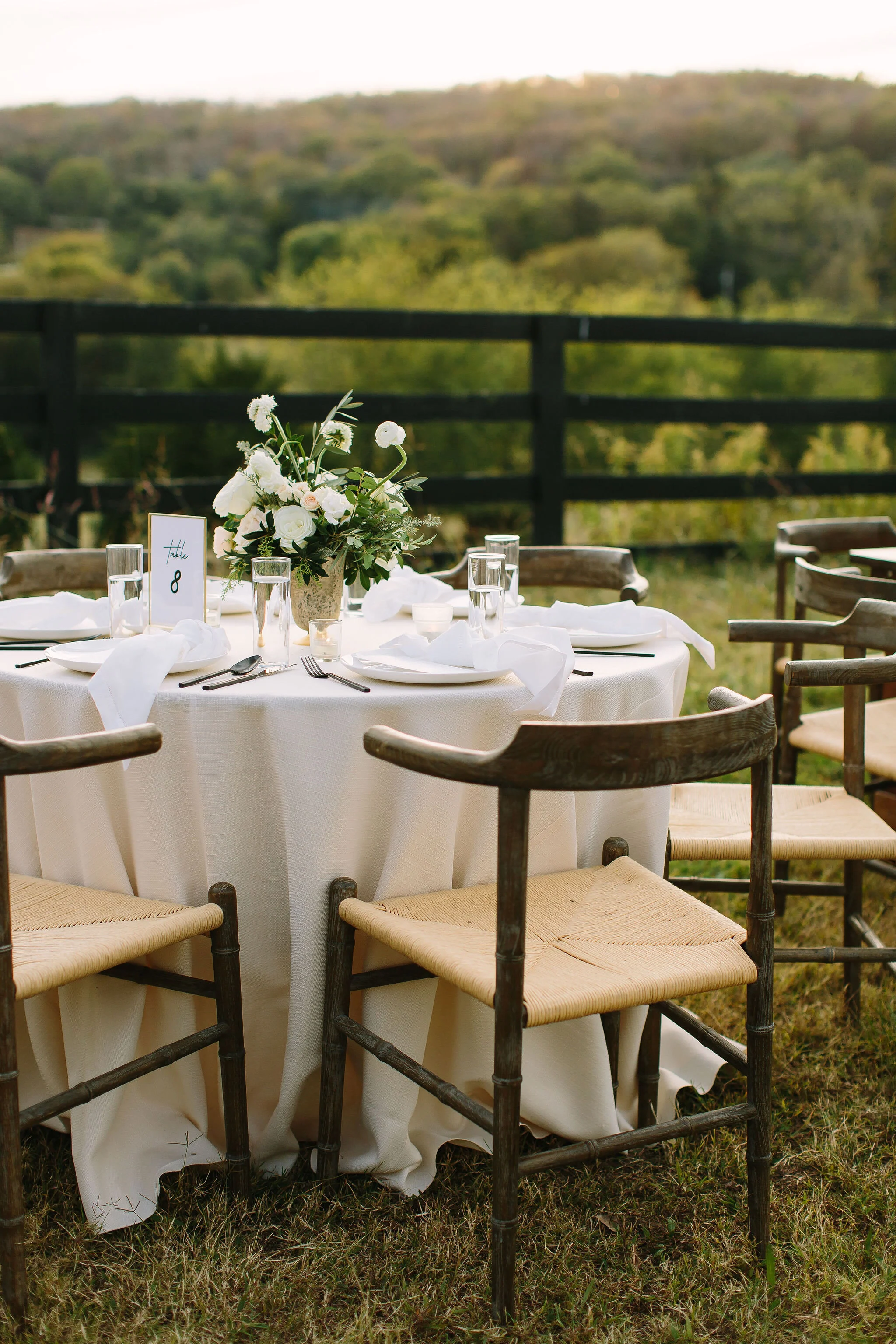 Whimsical floral centerpiece in a gold compote vase with white ranunculus, garden roses, and greenery. Nashville wedding florist at Bloomsbury Farm.