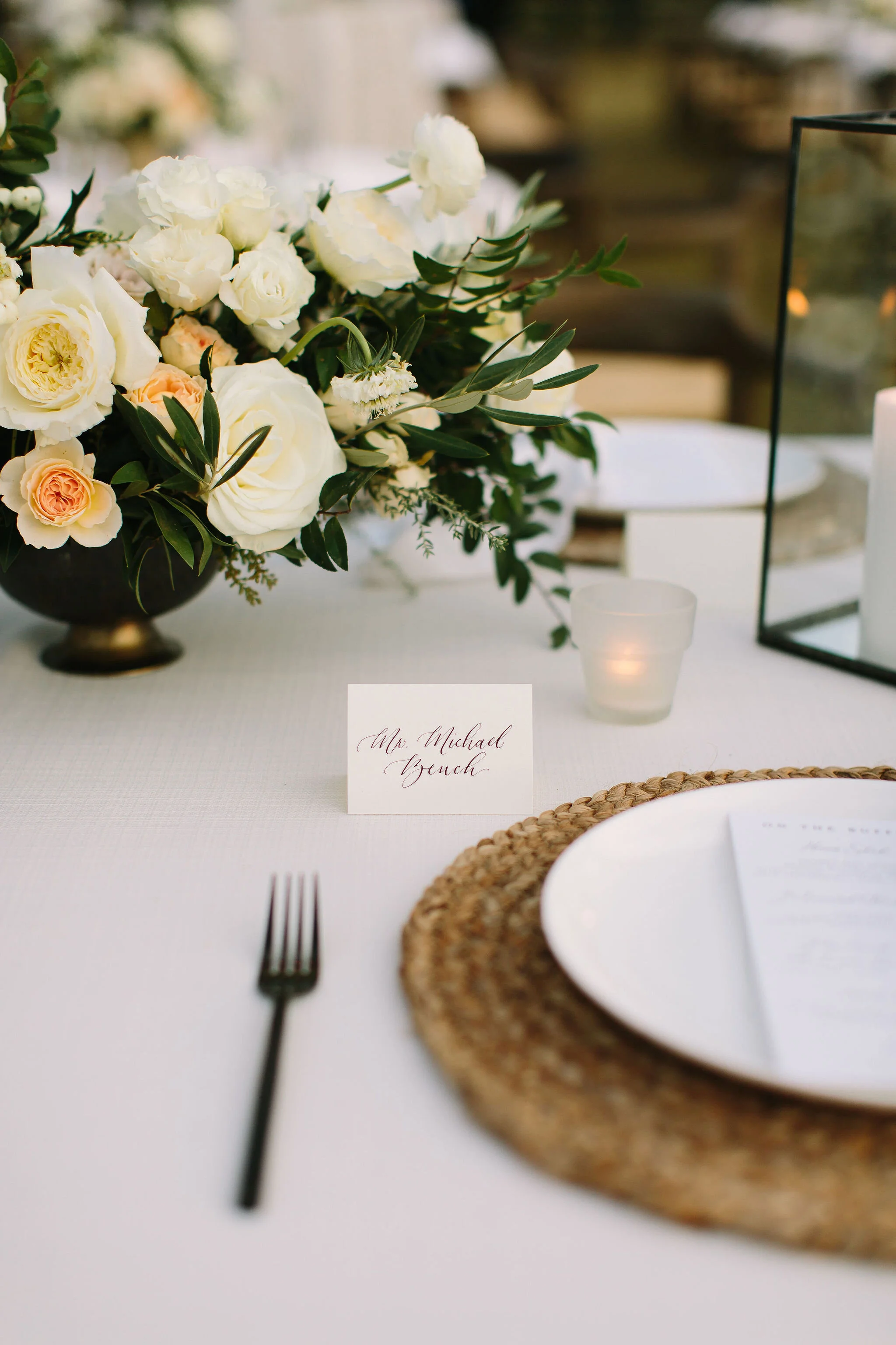 Whimsical floral centerpiece in a gold compote vase with white ranunculus, garden roses, and greenery. Nashville wedding florist at Bloomsbury Farm.