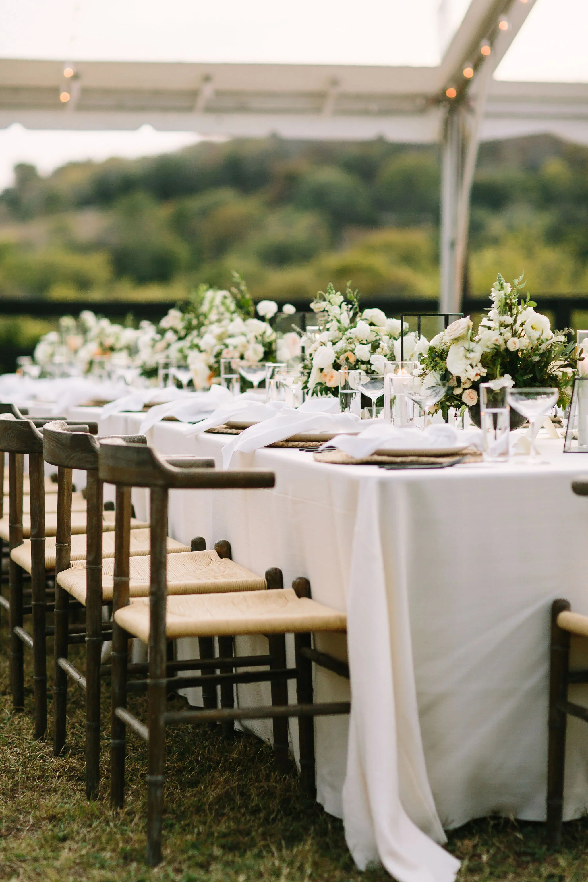 Whimsical floral centerpiece in a gold compote vase with white ranunculus, garden roses, and greenery. Nashville wedding florist at Bloomsbury Farm.