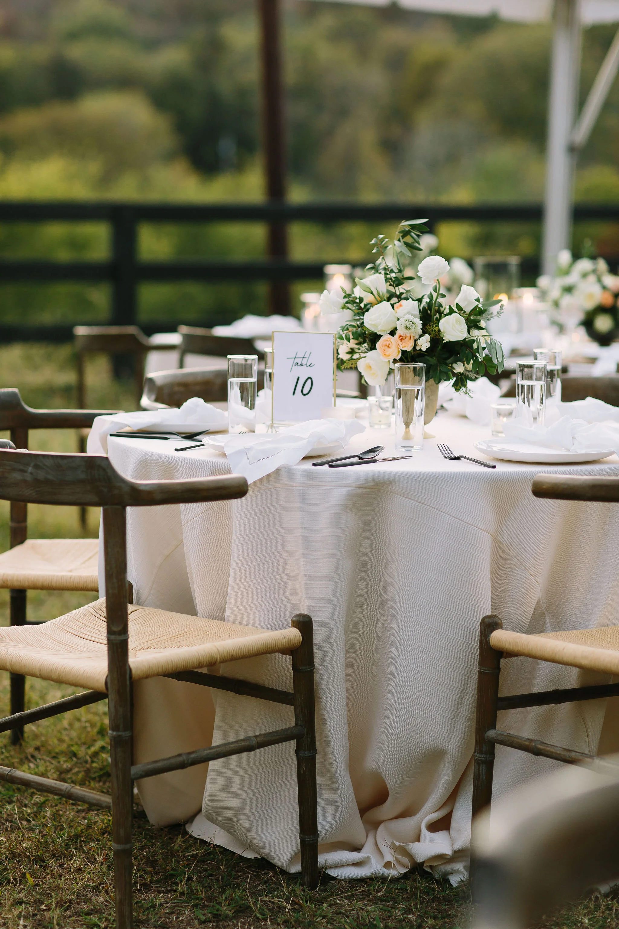 Whimsical floral centerpiece in a gold compote vase with white ranunculus, garden roses, and greenery. Nashville wedding florist at Bloomsbury Farm.