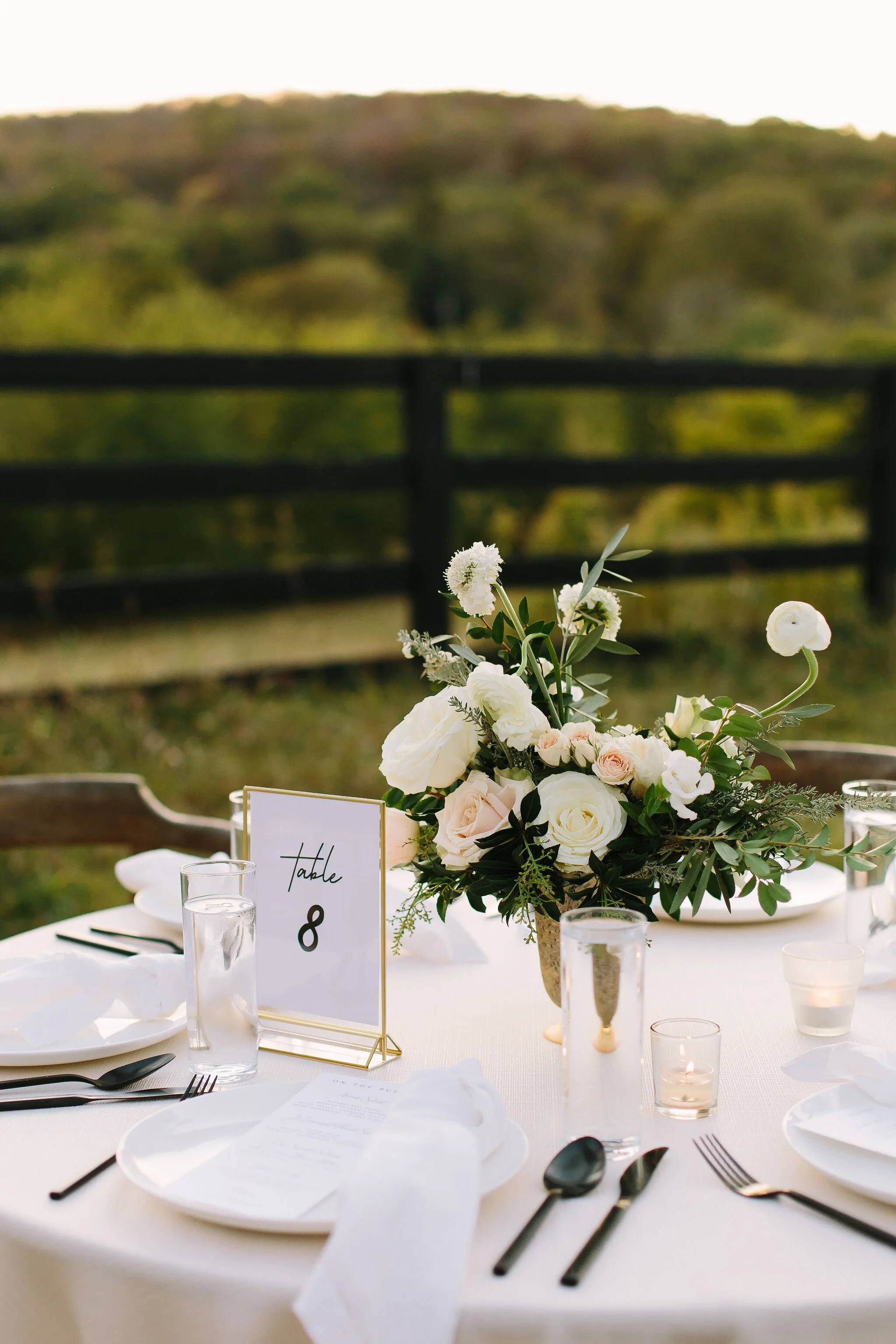 Olive branches styled around minimal black lanterns. Nashville wedding floral design.