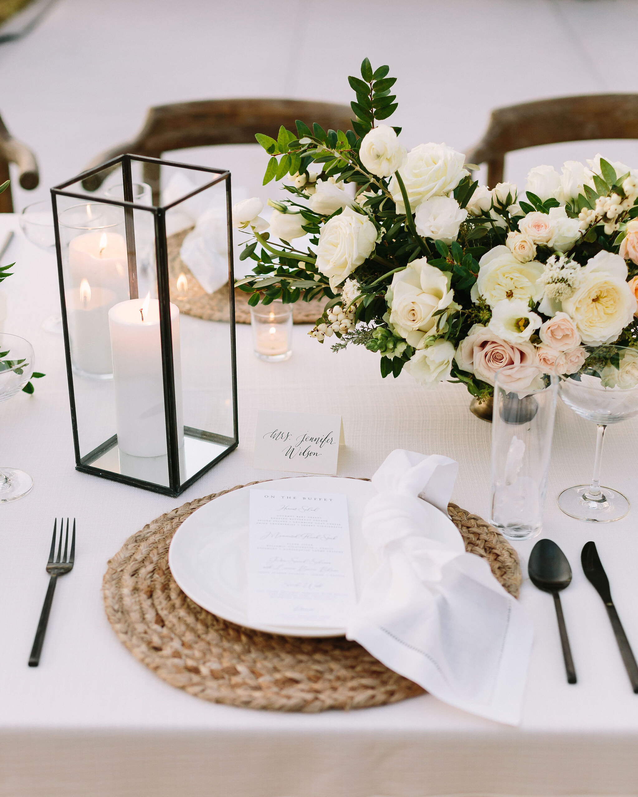 Whimsical floral centerpiece in a gold compote vase with white ranunculus, garden roses, and greenery. Nashville wedding florist at Bloomsbury Farm.