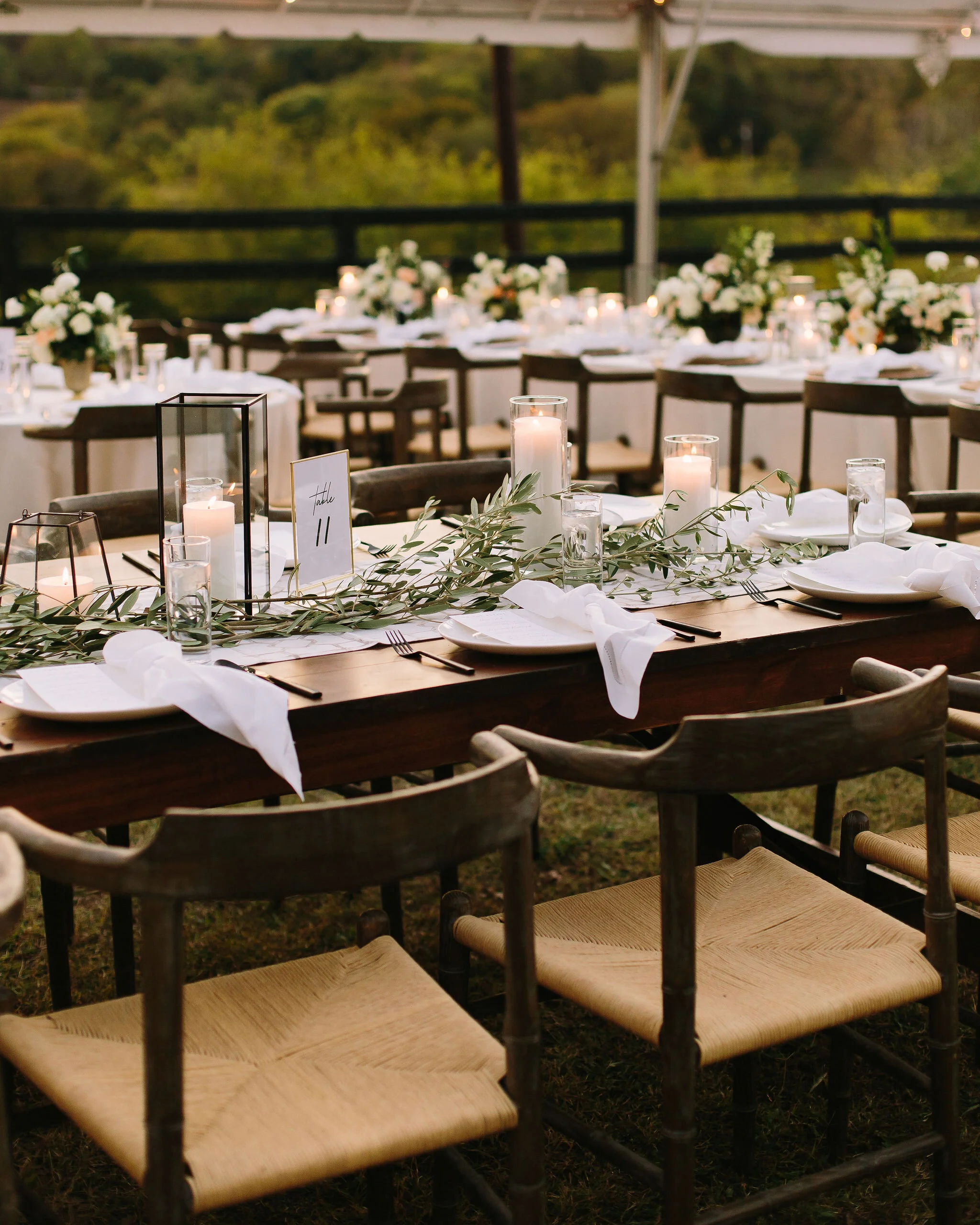 Olive branches styled around minimal black lanterns. Nashville wedding floral design.
