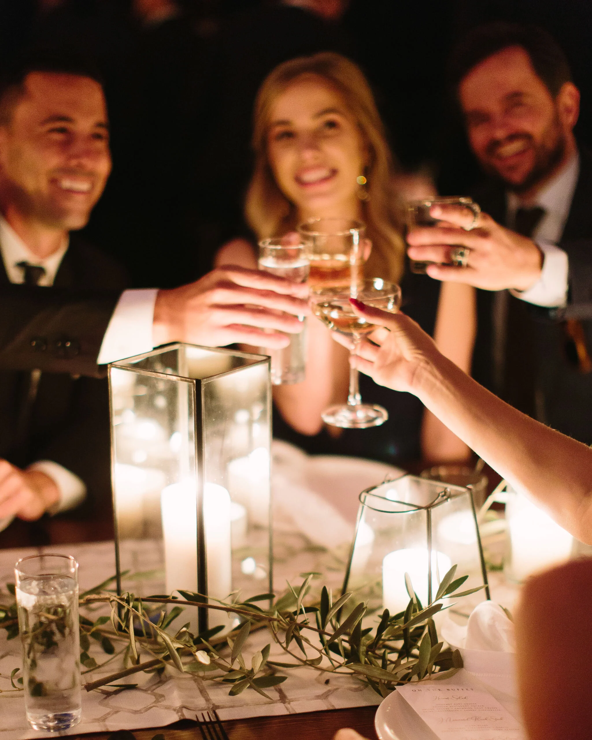 Olive branches styled around minimal black lanterns. Nashville wedding floral design.