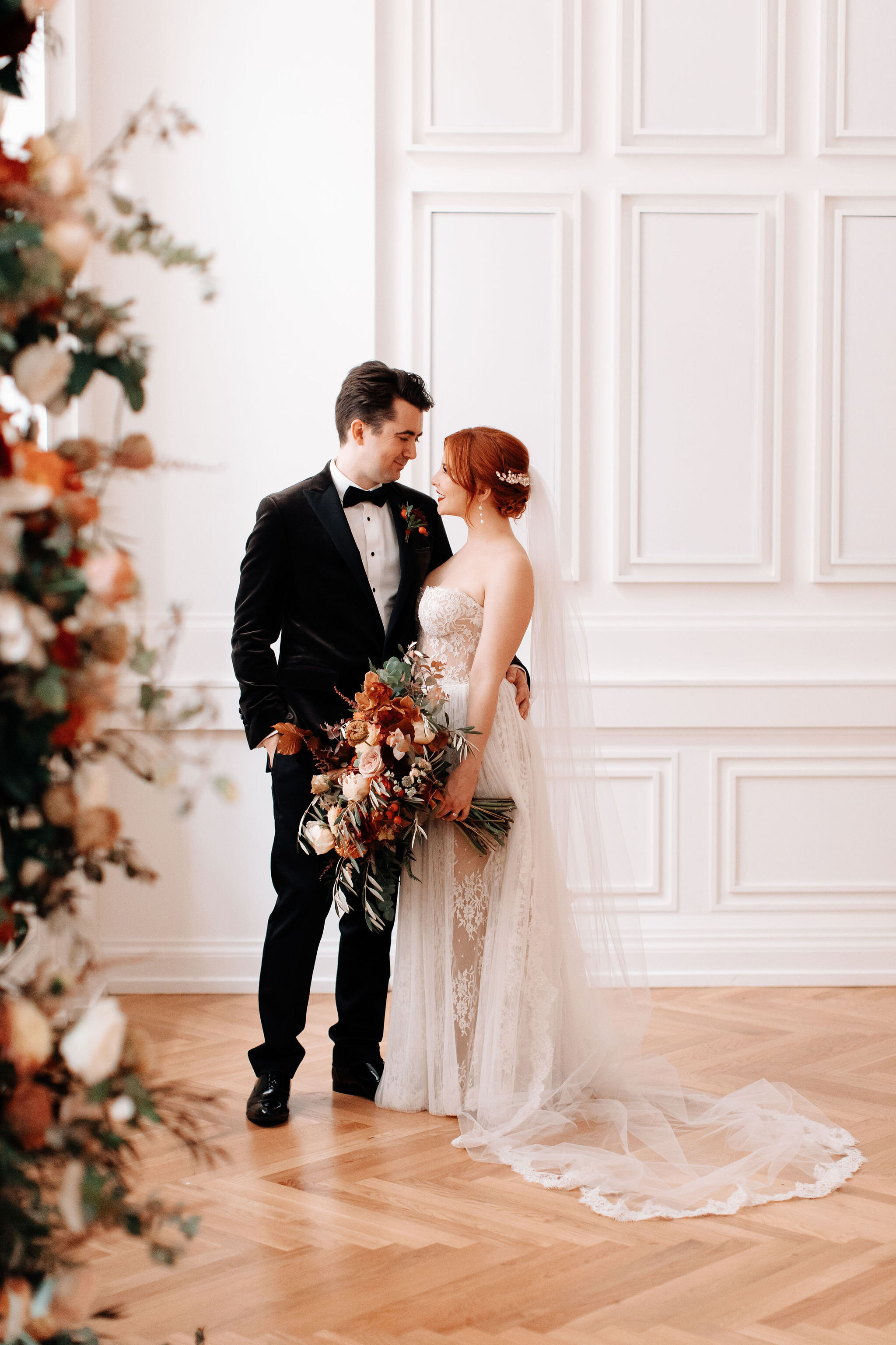 Growing floral installation on either side of the window for the wedding ceremony backdrop, with untamed greenery, rusty orange and burnt sienna garden roses, and lots of texture. Nashville wedding florist at the Noelle hotel.