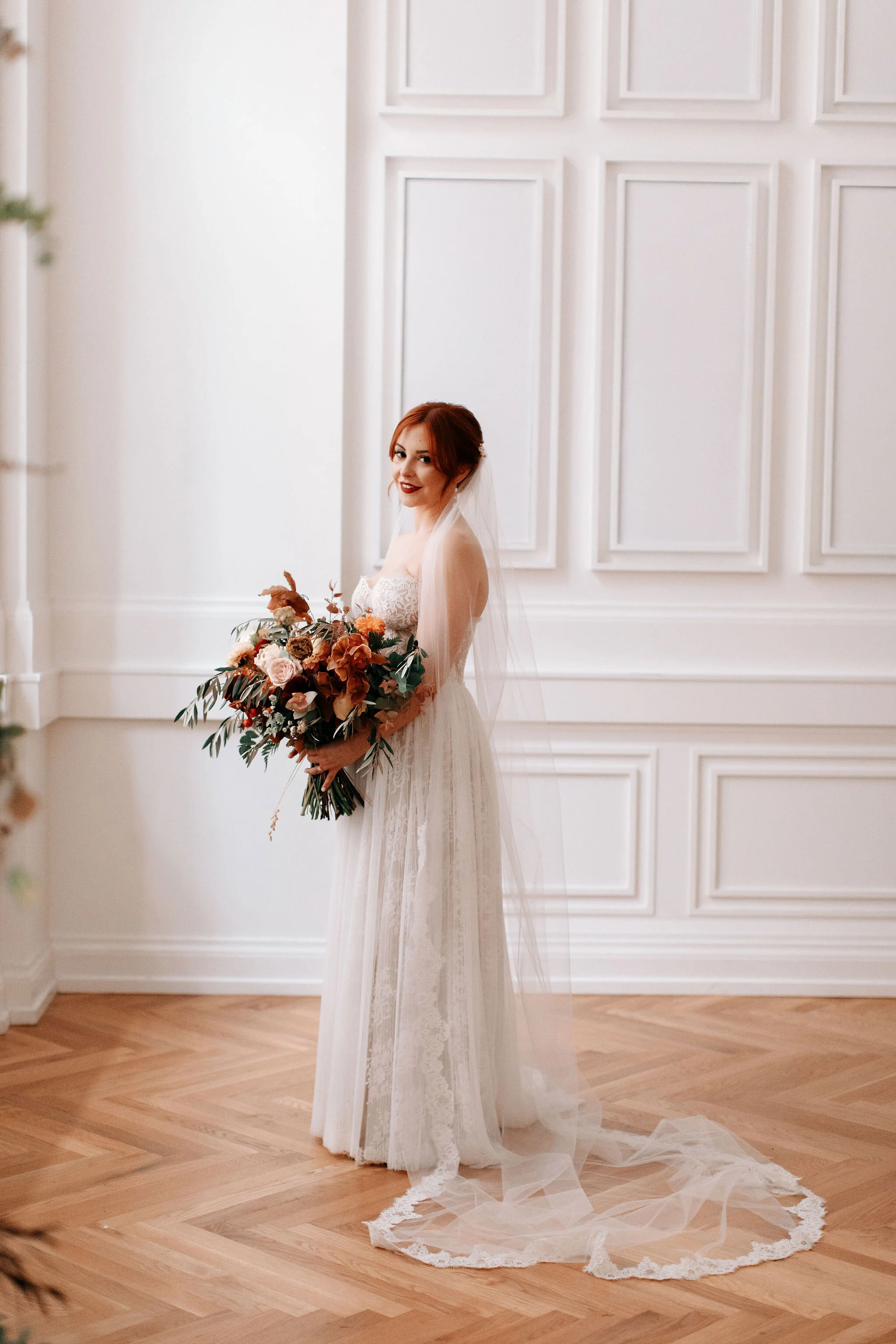 Bridal bouquet in shades of burnt orange, rust, burgundy, copper, and greenery, with dahlias, ranunculus, rosehips, and olive branches. Nashville wedding floral designer.