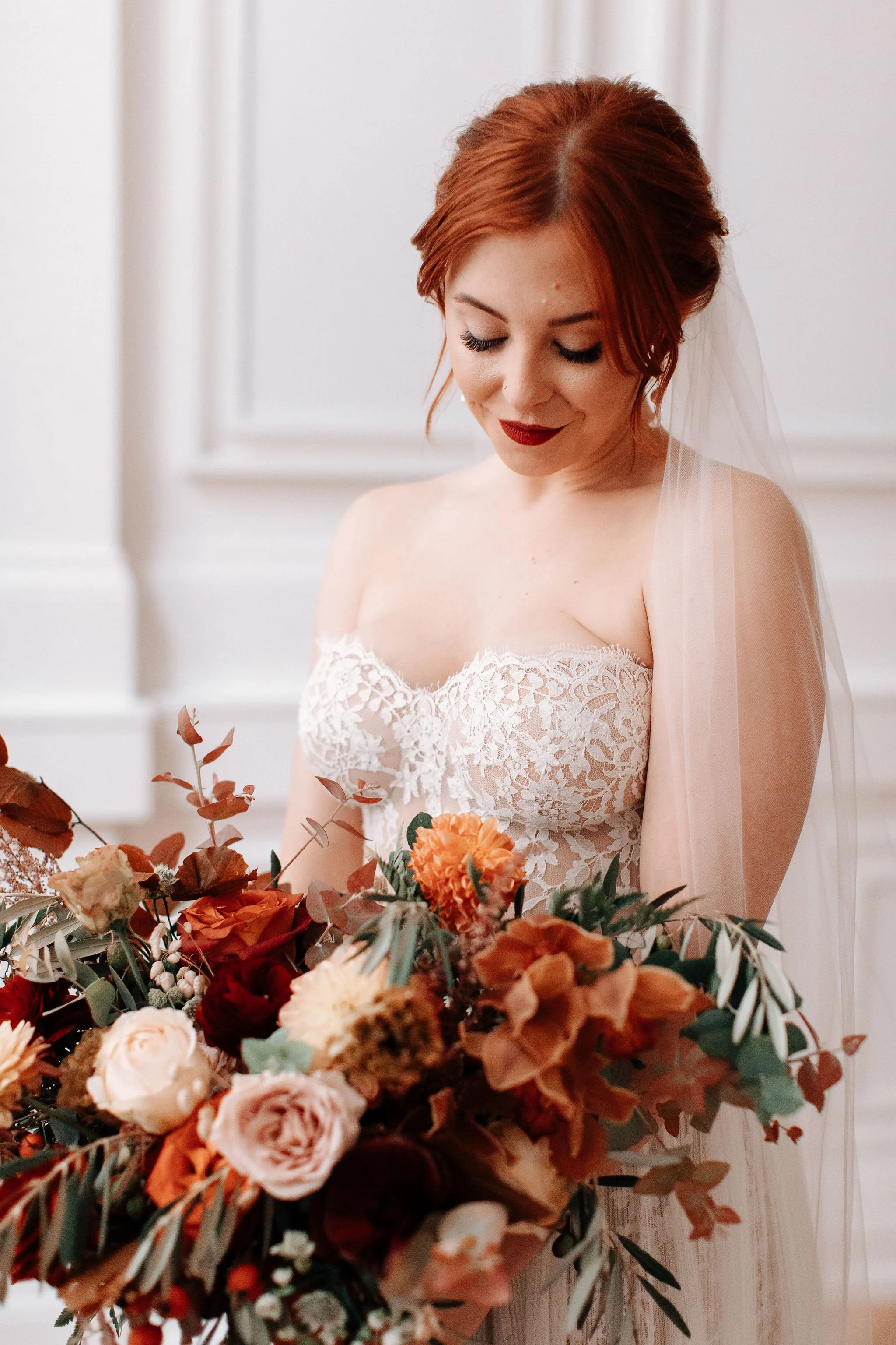 Bridal bouquet in shades of burnt orange, rust, burgundy, copper, and greenery, with dahlias, ranunculus, rosehips, and olive branches. Nashville wedding floral designer.
