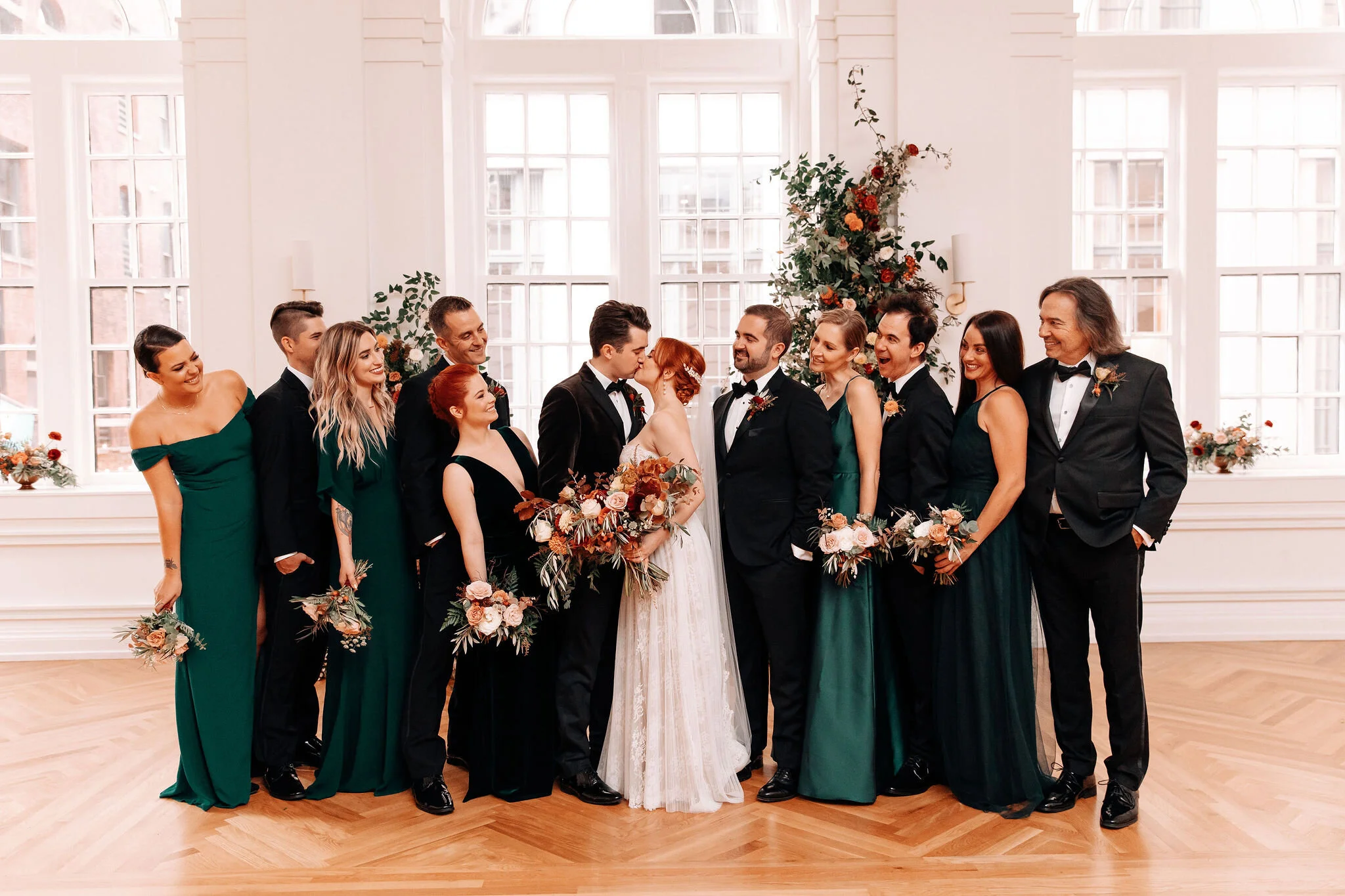 Emerald green bridesmaid dresses, black tuxes, redhead bride, and rusty red and burnt orange florals with natural greenery. Nashville wedding florist at the Noelle.