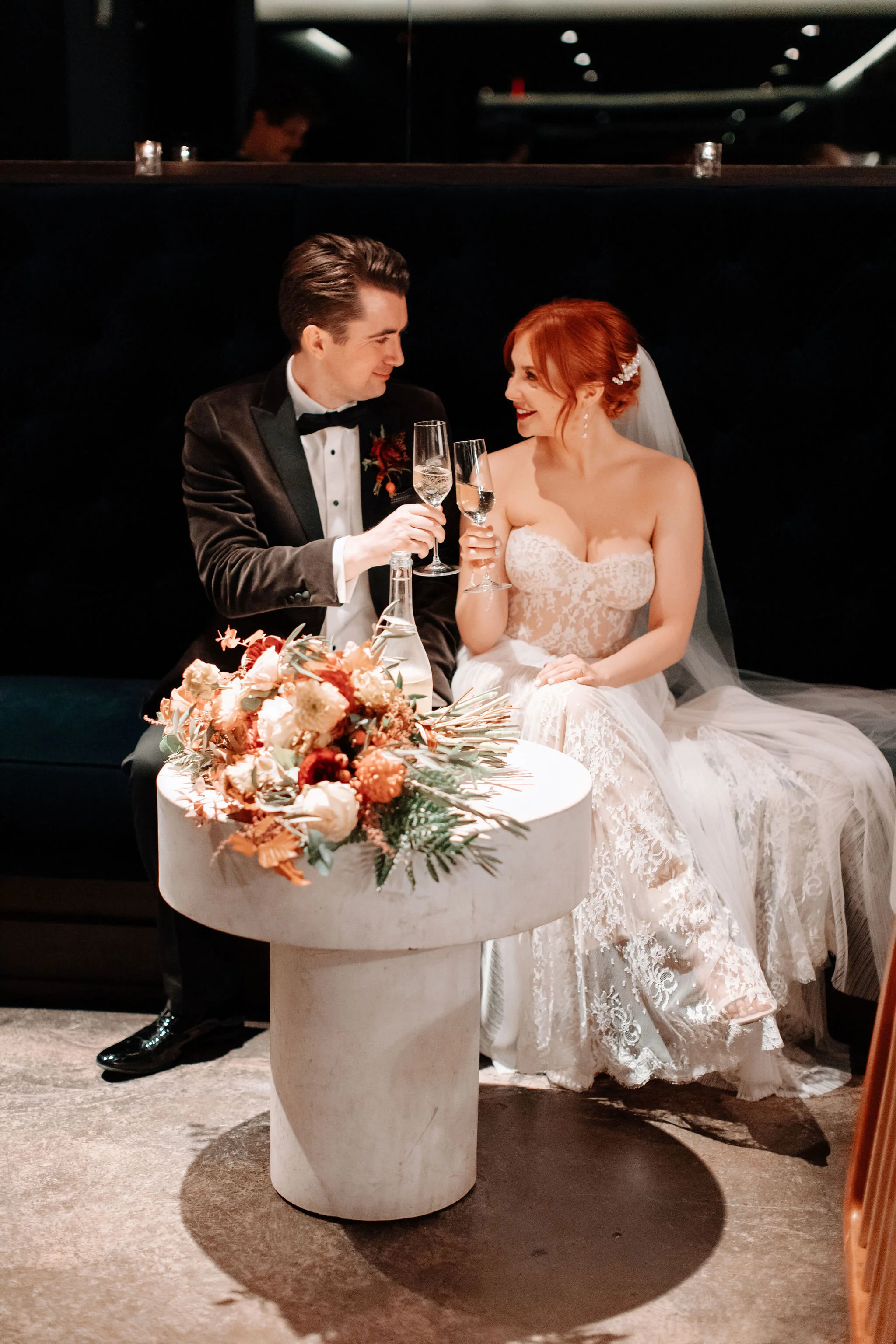 Bridal bouquet in shades of burnt orange, rust, burgundy, copper, and greenery, with dahlias, ranunculus, rosehips, and olive branches. Nashville wedding floral designer.