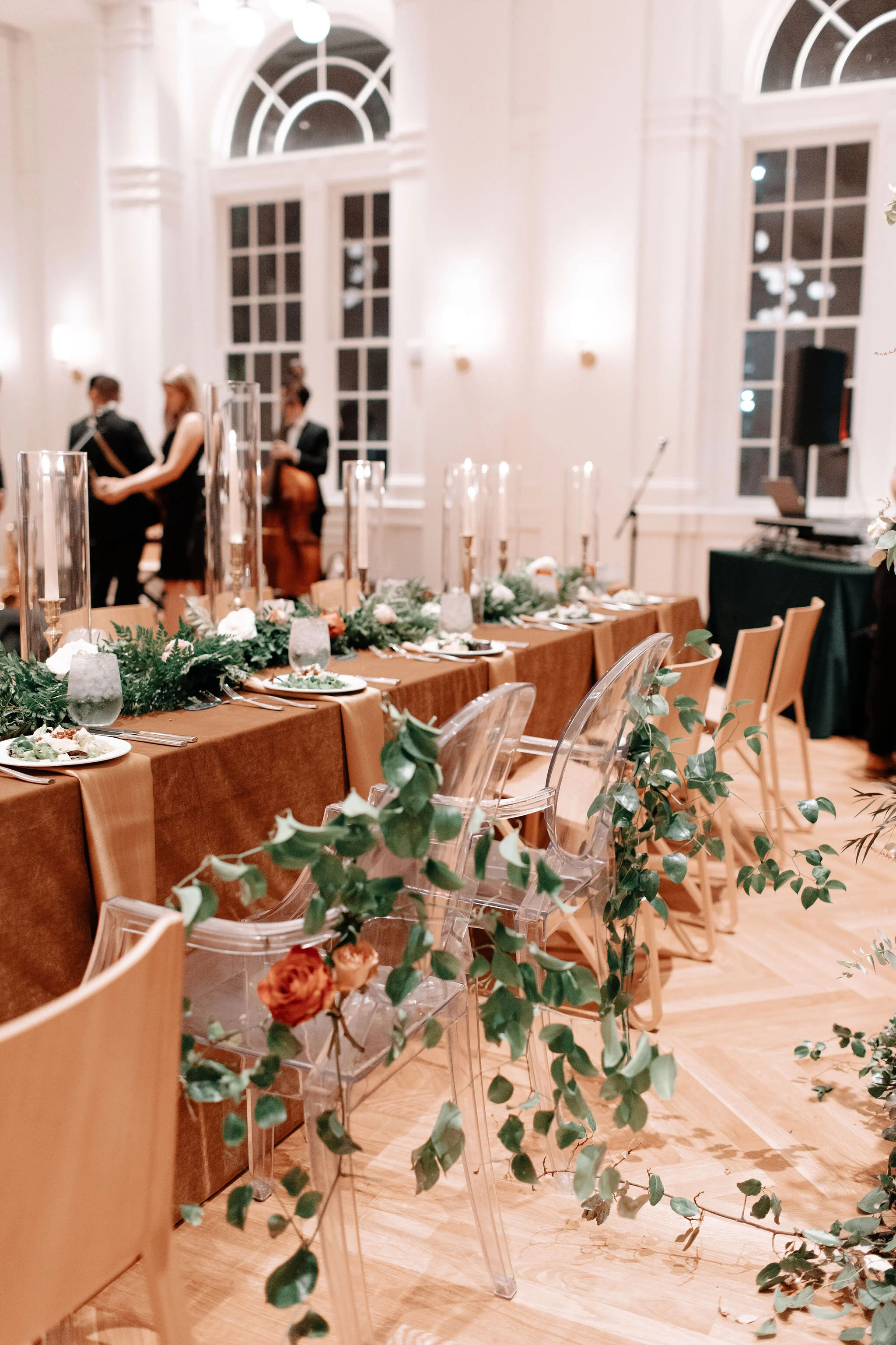 Bride and groom ghost chairs with floral and greenery accents. Noelle hotel wedding flowers.