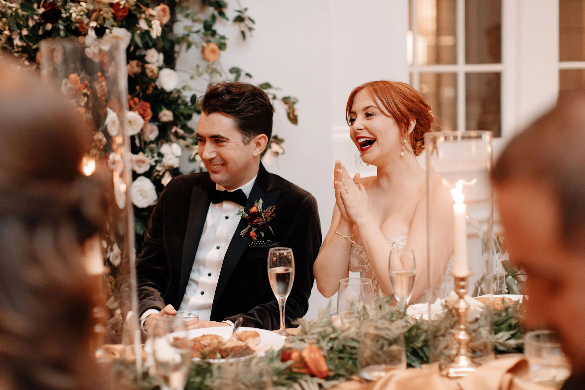 Head table with rust velvet linen, lush garland of ferns and burnt orange garden roses, and brass candlesticks. Nashville wedding florist at the Noelle hotel.