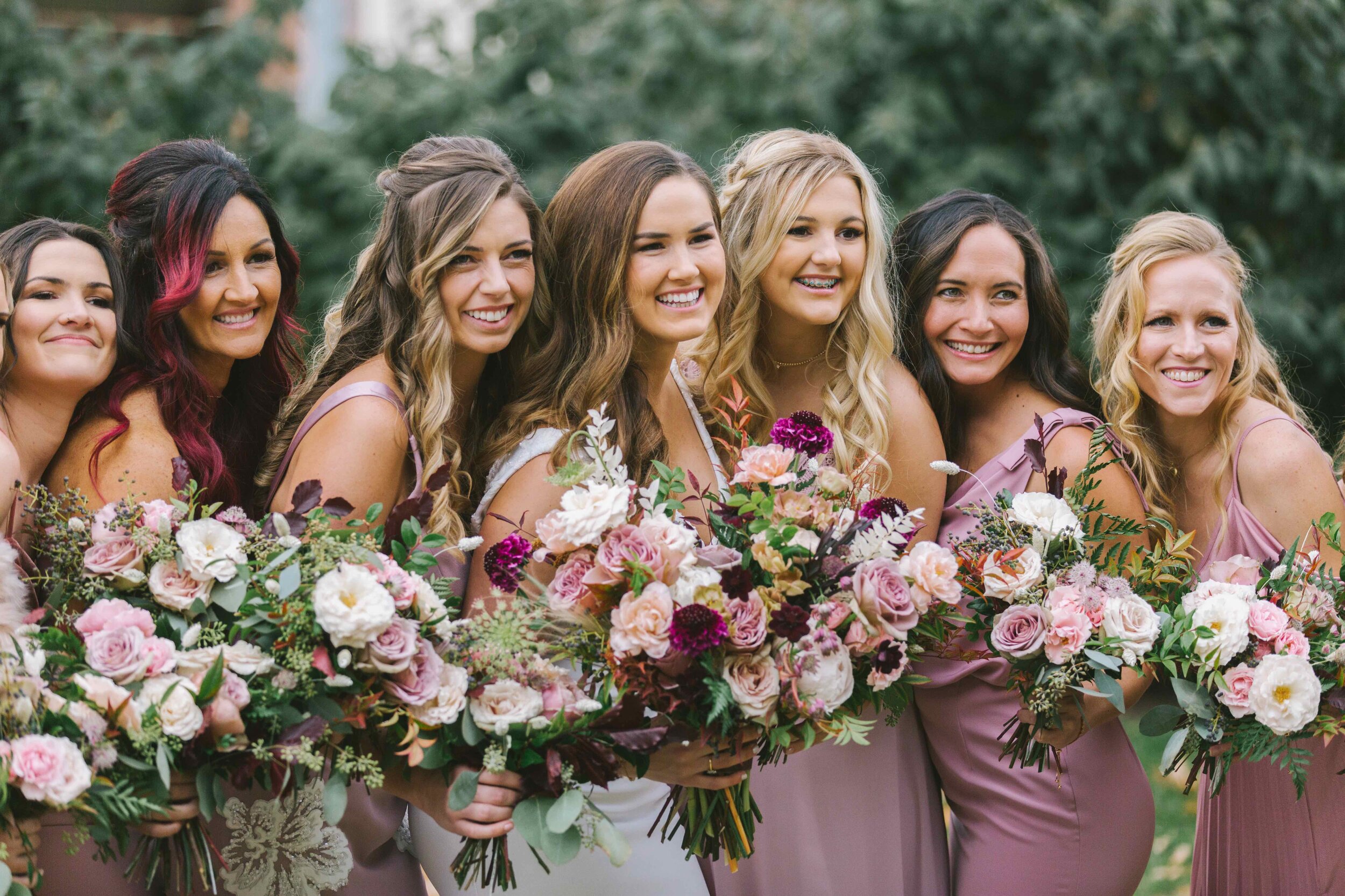 Whimsical bridal bouquet with mauve and blush garden roses and ranunculus, chocolate cosmos, chocolate lace flower, privet berries, white ferns, eggplant scabiosa, and natural greenery. Nashville wedding florist at the Cordelle.