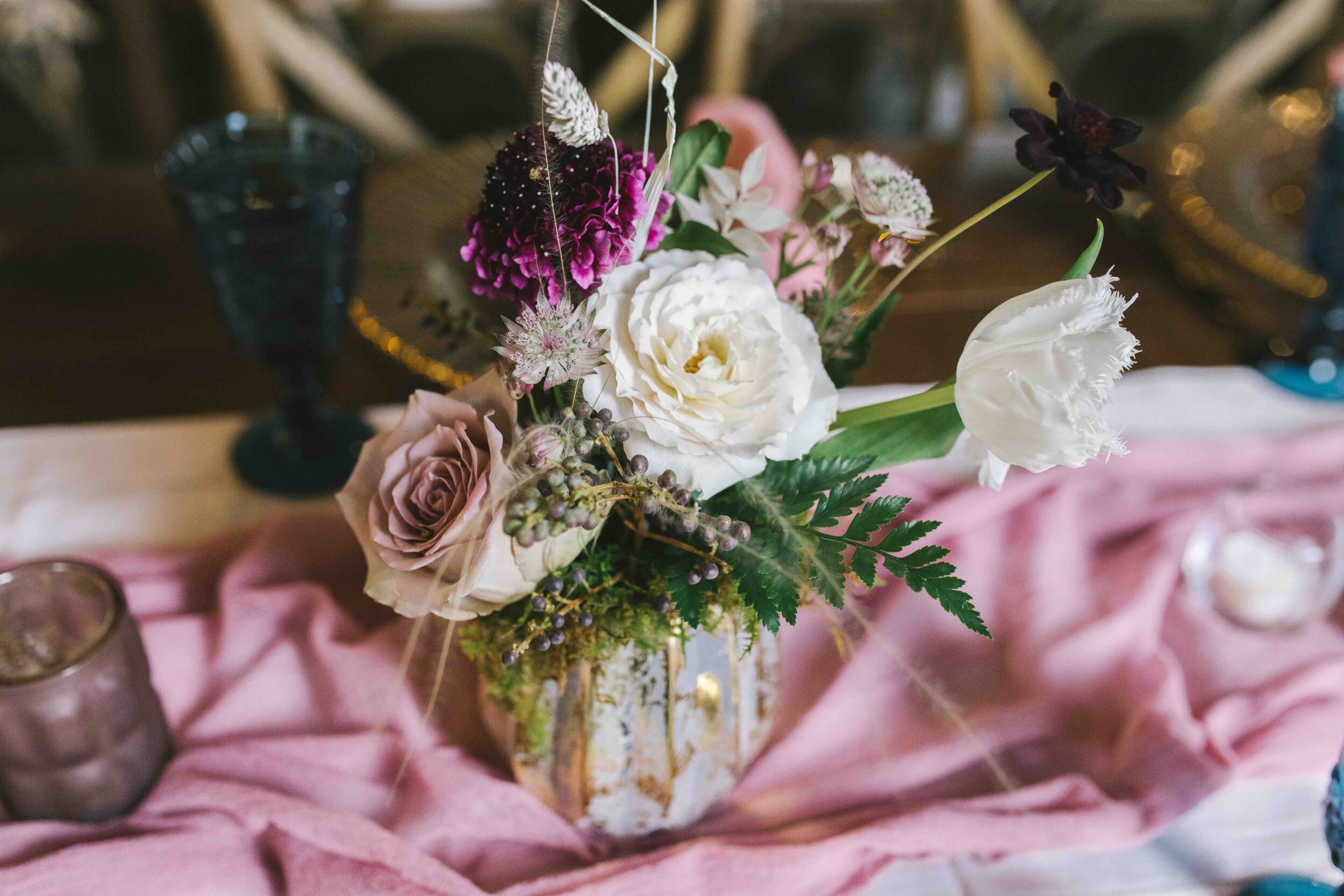 \Whimsical floral terrarium centerpieces with moss, dried white ferns, eggplant scabiosa, chocolate cosmos, privet berries, champagne, mauve, and blush roses, white tulips. and fall foliage and greenery. Nashville wedding florist at the Cordelle.
