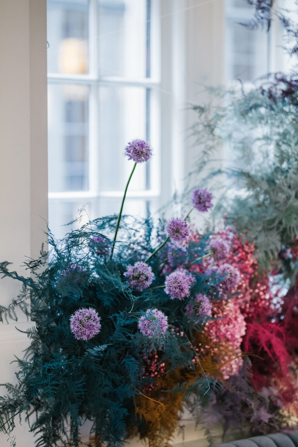Rainbow colored floral installation with painted and dyed baby’s breath and plums ferns. Modern, minimal, colorful wedding flowers at the Noelle Hotel in downtown Nashville.