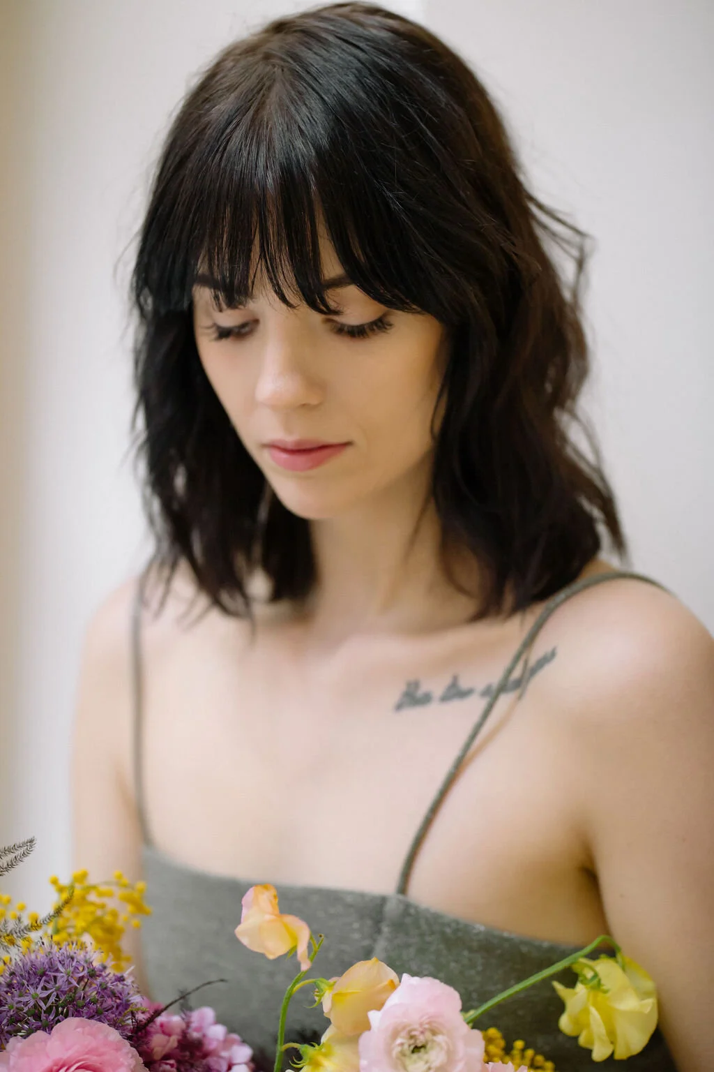 Modern, colorful bridal bouquet with yellow sweet peas, purple allium, pink and peach ranunculus, golden acacia, and painted eggplant plums fern. Nashville wedding florist. Printer’s Alley portraits.
