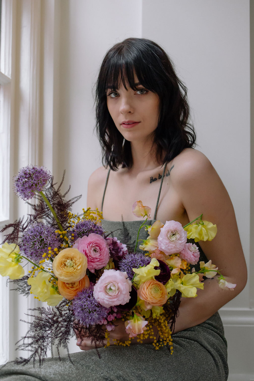 Modern, colorful bridal bouquet with yellow sweet peas, purple allium, pink and peach ranunculus, golden acacia, and painted eggplant plums fern. Nashville wedding florist. Printer’s Alley portraits.