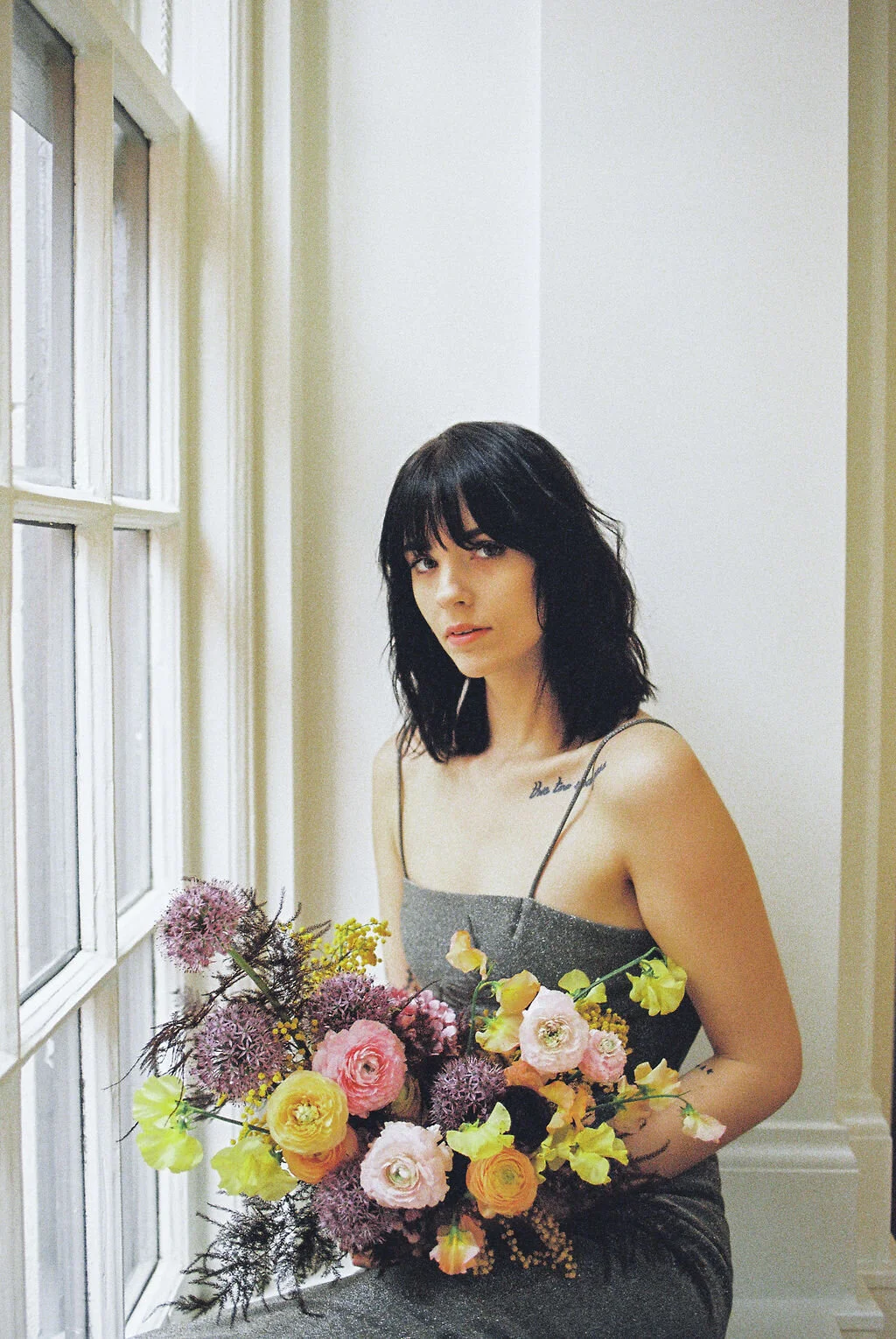 Modern, colorful bridal bouquet with yellow sweet peas, purple allium, pink and peach ranunculus, golden acacia, and painted eggplant plums fern. Nashville wedding florist. Printer’s Alley portraits.