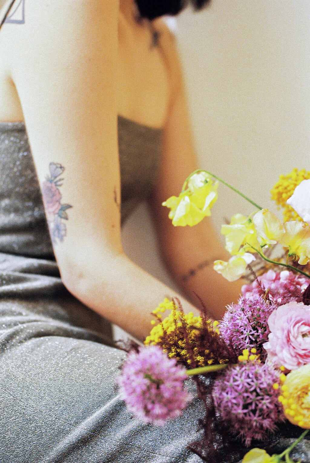 Modern, colorful bridal bouquet with yellow sweet peas, purple allium, pink and peach ranunculus, golden acacia, and painted eggplant plums fern. Nashville wedding florist. Printer’s Alley portraits.