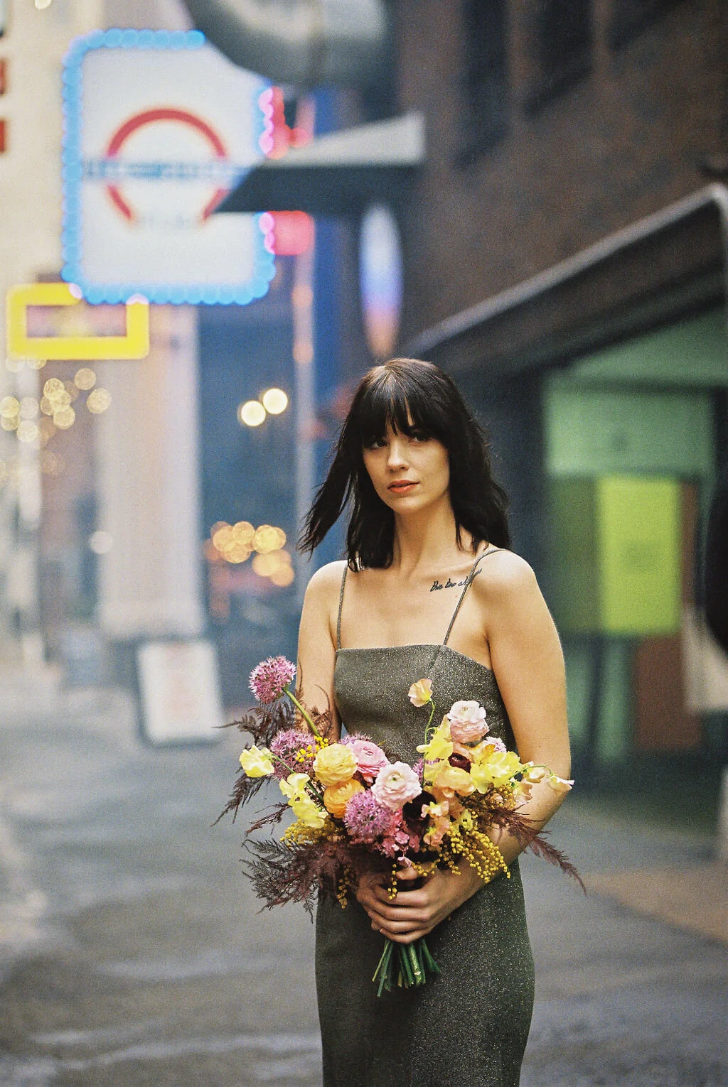 Modern, colorful bridal bouquet with yellow sweet peas, purple allium, pink and peach ranunculus, golden acacia, and painted eggplant plums fern. Nashville wedding florist. Printer’s Alley portraits.