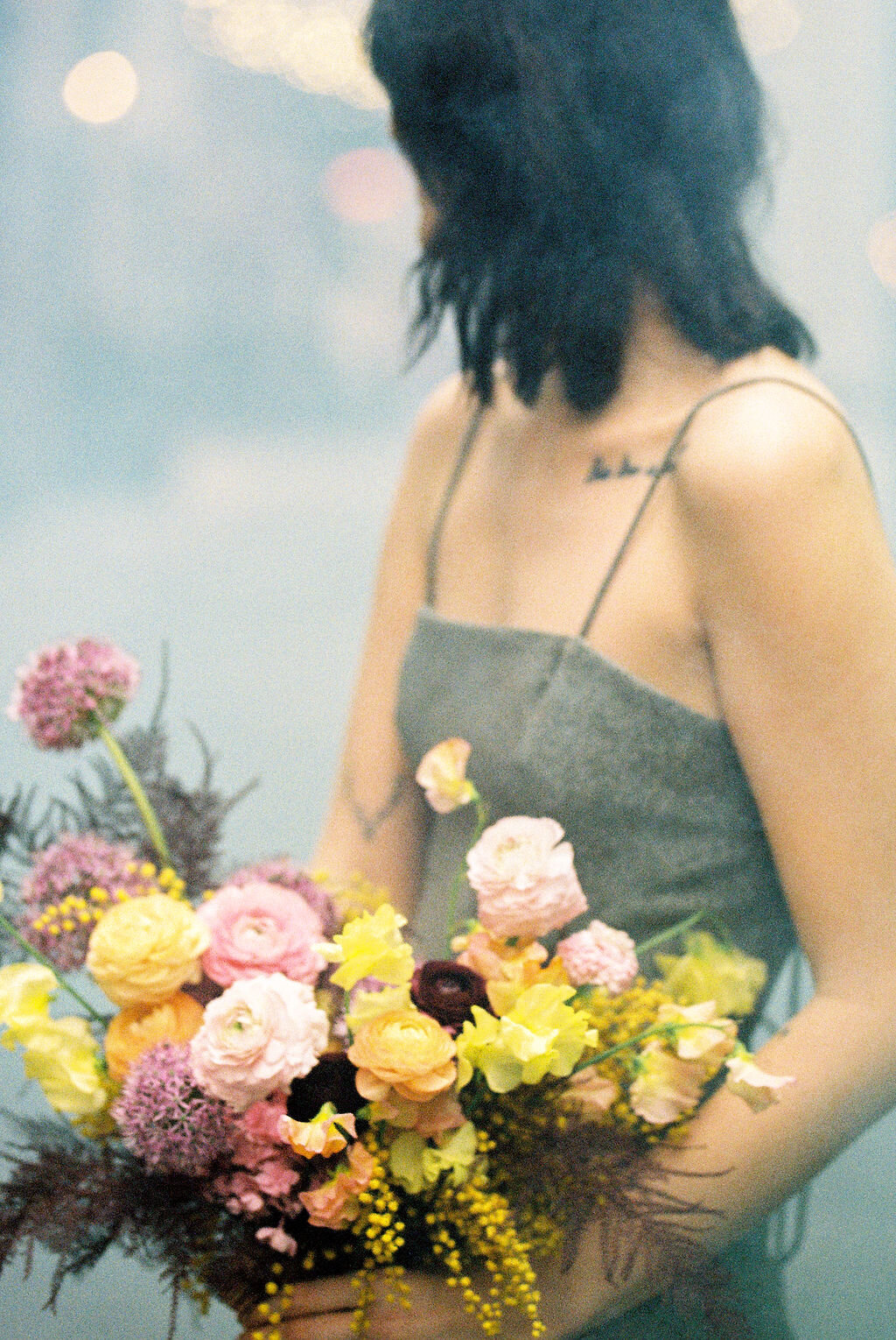 Modern, colorful bridal bouquet with yellow sweet peas, purple allium, pink and peach ranunculus, golden acacia, and painted eggplant plums fern. Nashville wedding florist. Printer’s Alley portraits.