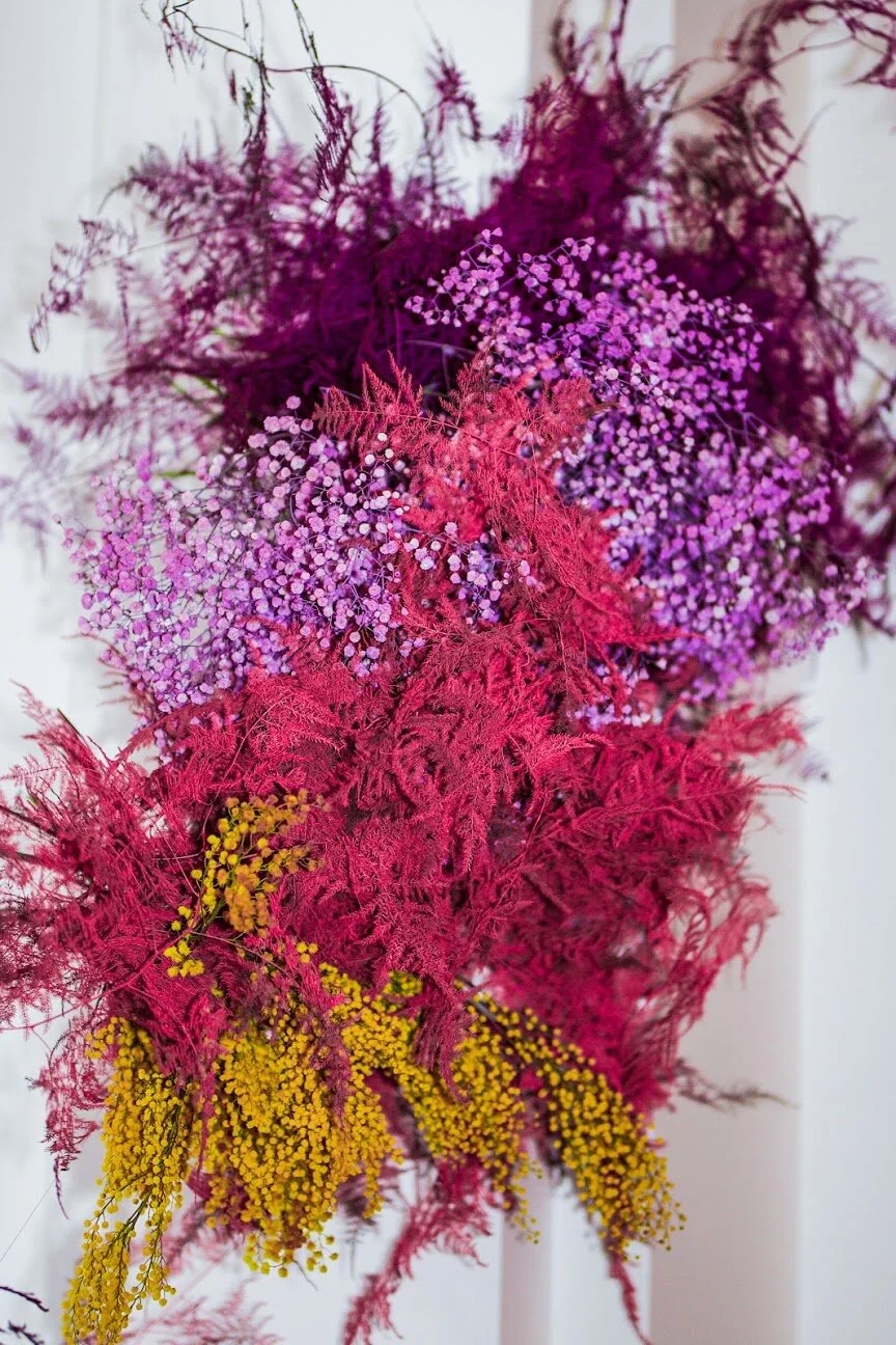 Rainbow colored floral installation with painted and dyed baby’s breath and plums ferns. Modern, minimal, colorful wedding flowers at the Noelle Hotel in downtown Nashville.