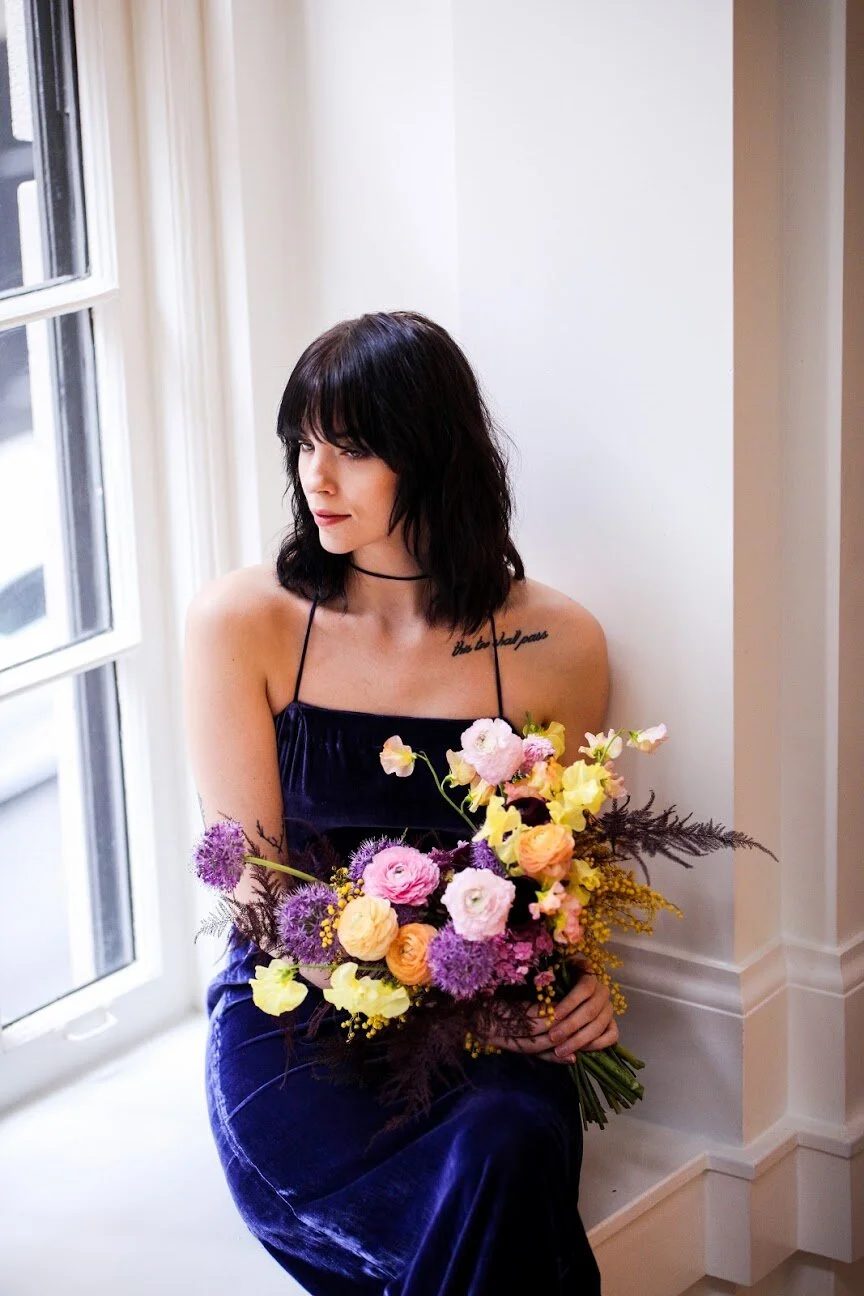 Modern, colorful bridal bouquet with yellow sweet peas, purple allium, pink and peach ranunculus, golden acacia, and painted eggplant plums fern. Nashville wedding florist. Printer’s Alley portraits.